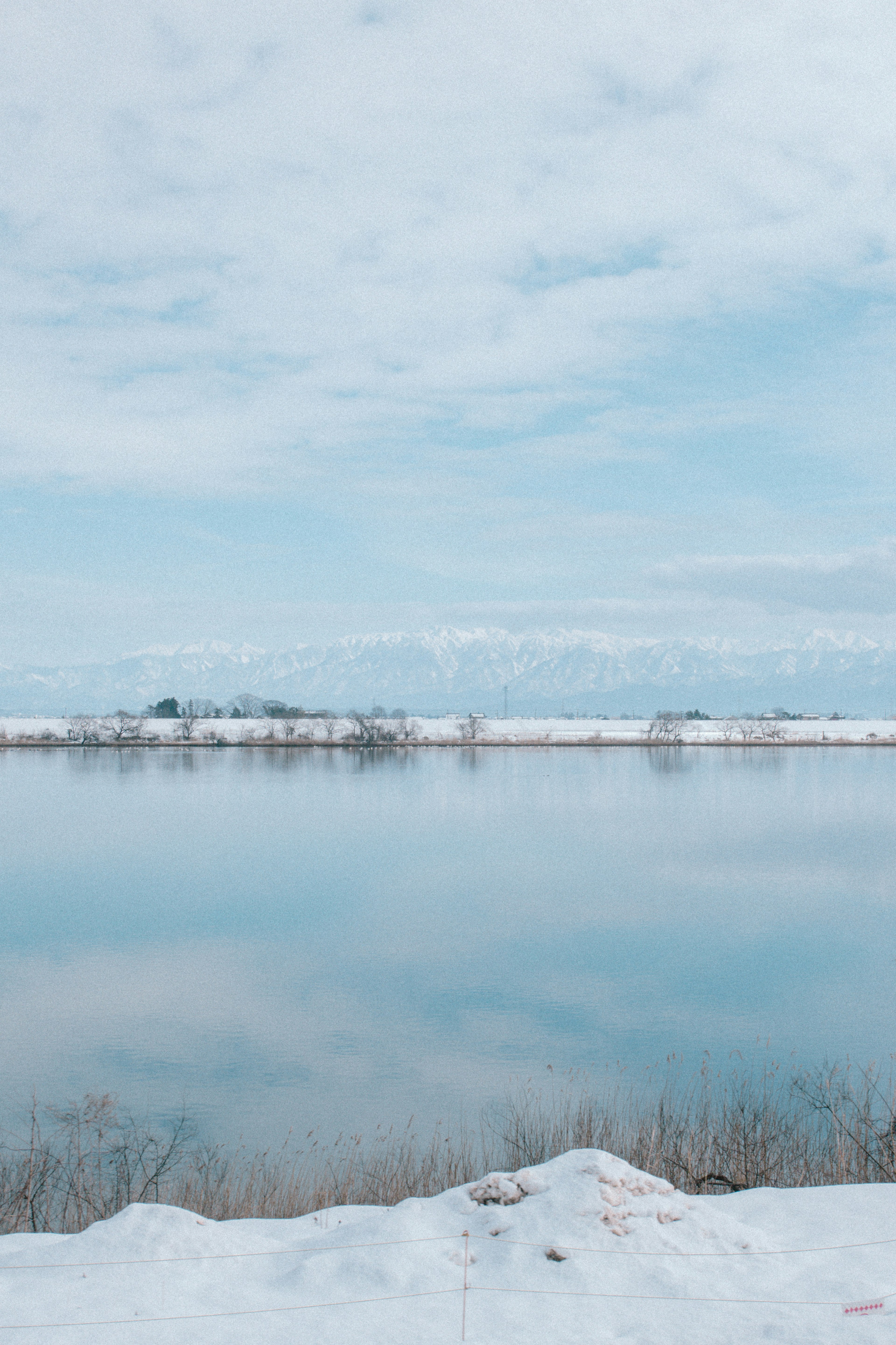 Paysage serein avec un sol enneigé et une surface d'eau calme