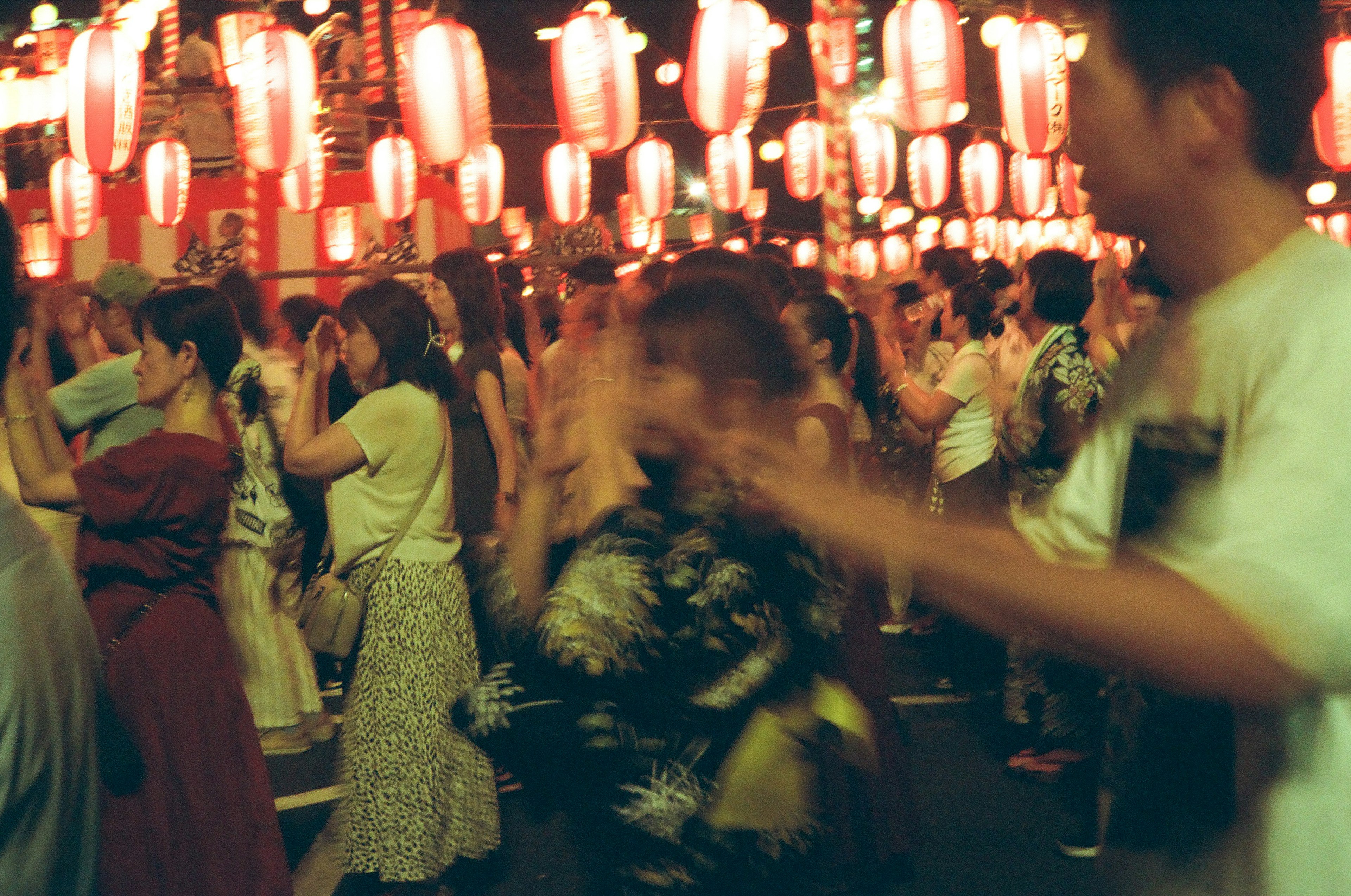 賑やかな祭りの夜の風景で提灯が灯り人々が踊っている様子