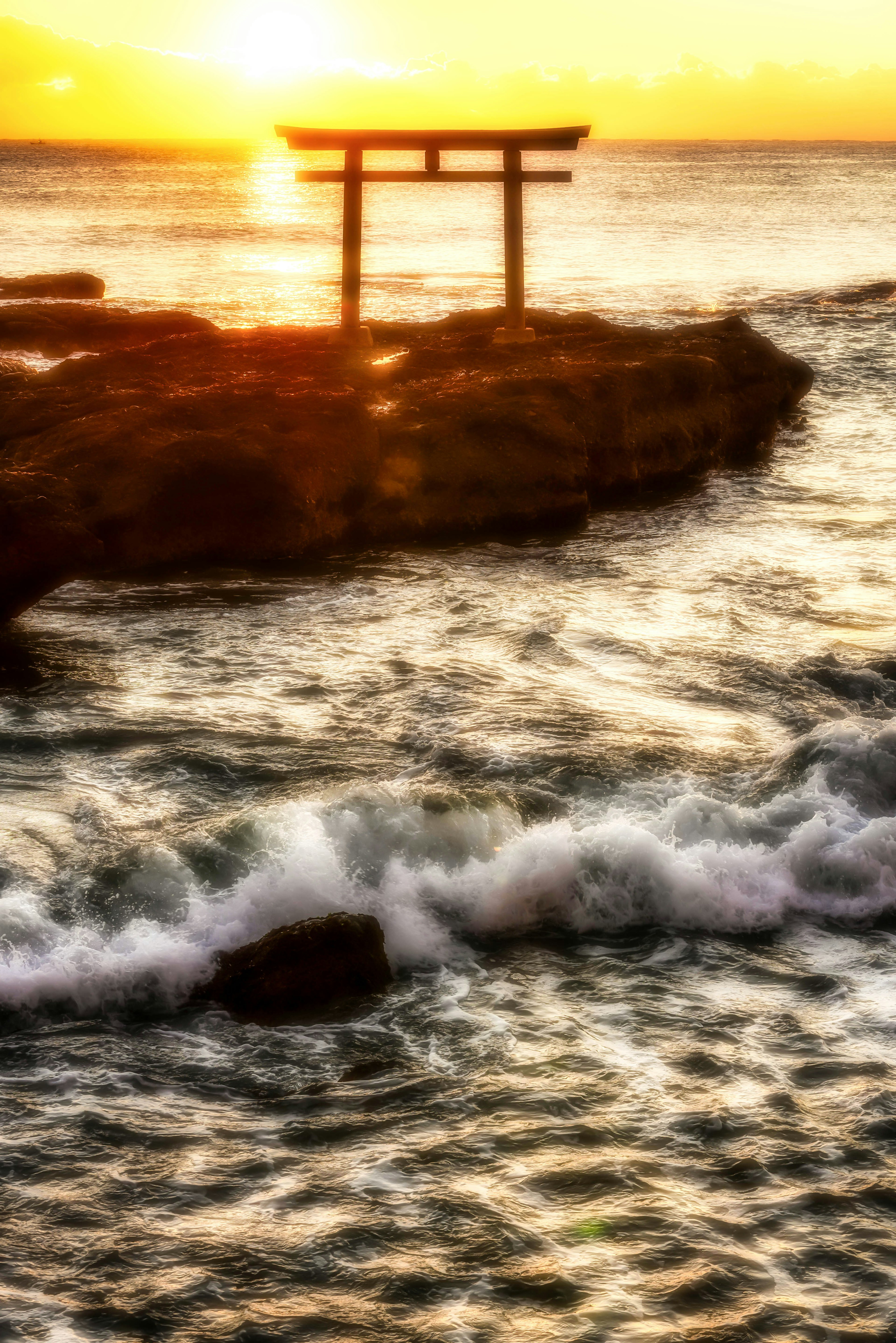 夕日の中の海と鳥居の風景