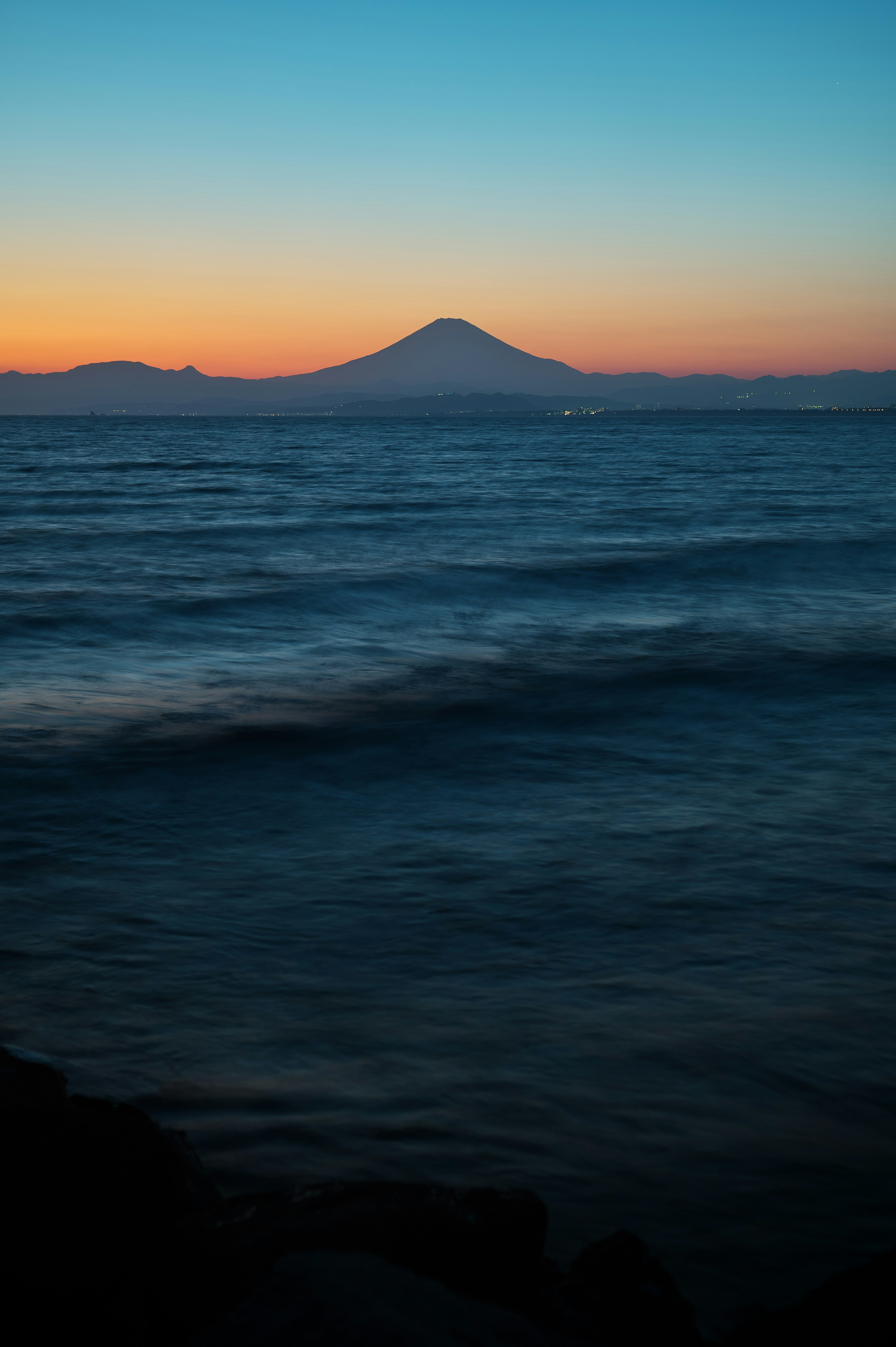 海洋上美麗的日落景色與山的輪廓