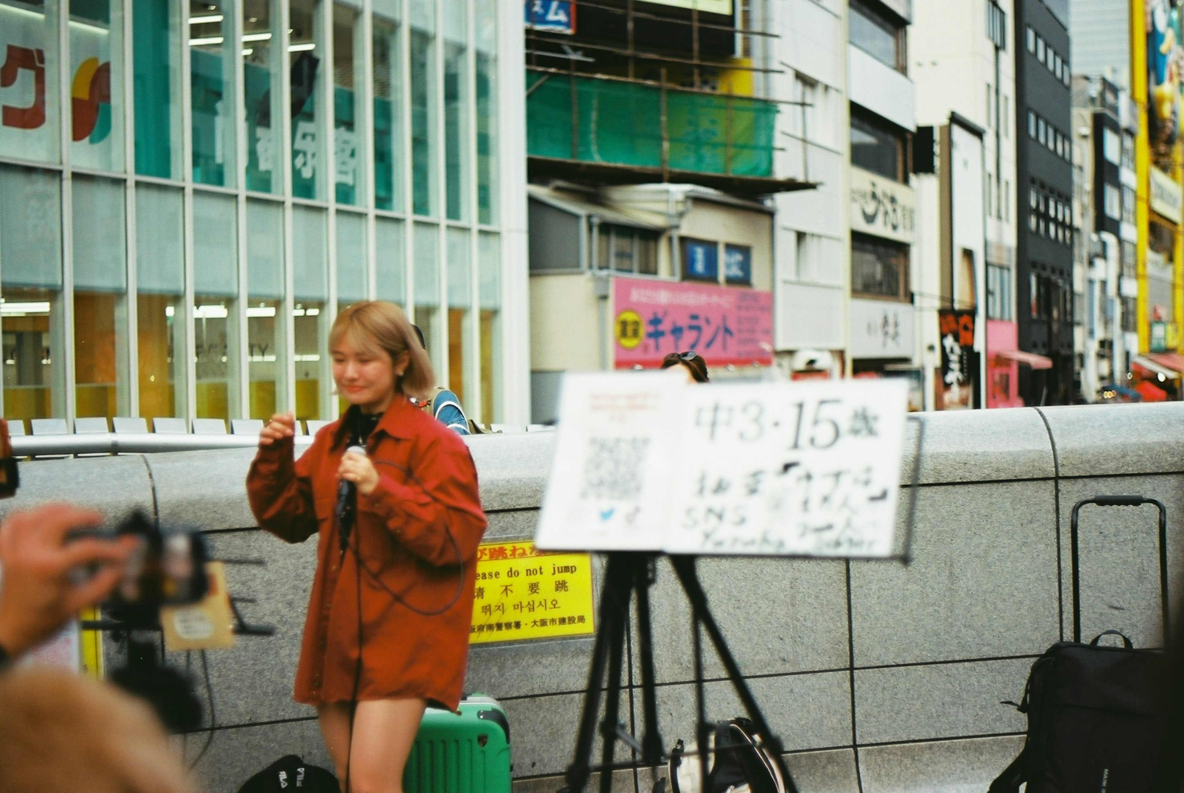 街頭でカメラを持つ女性とパフォーマンスボード