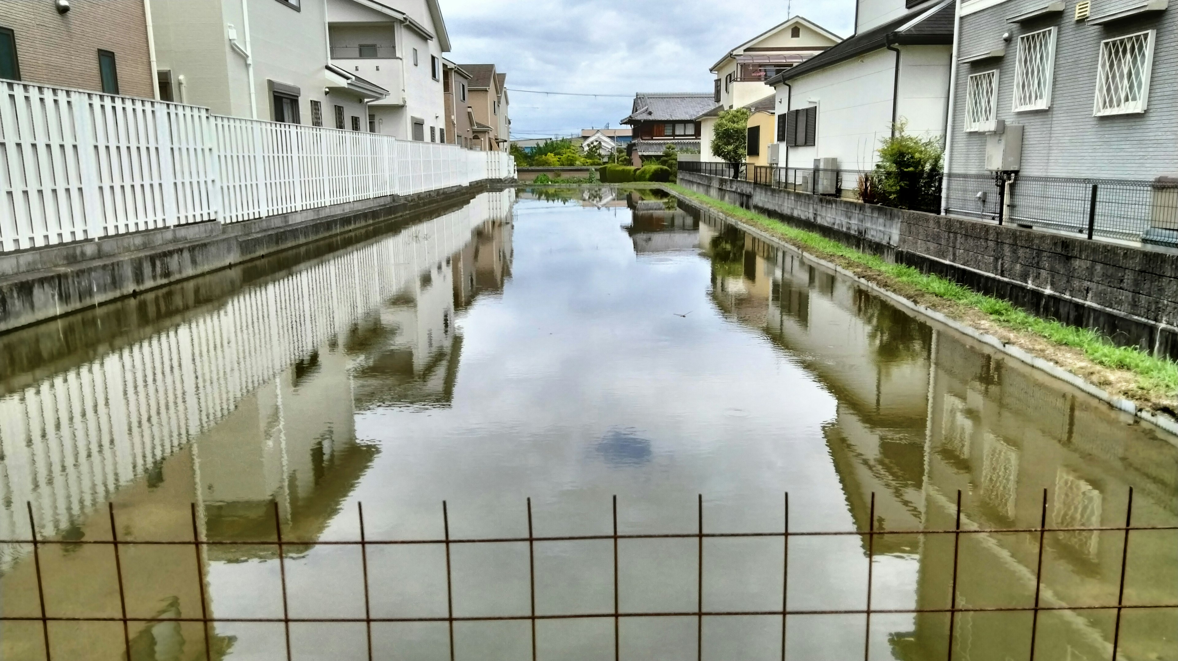 静かな水面に映る住宅街の風景