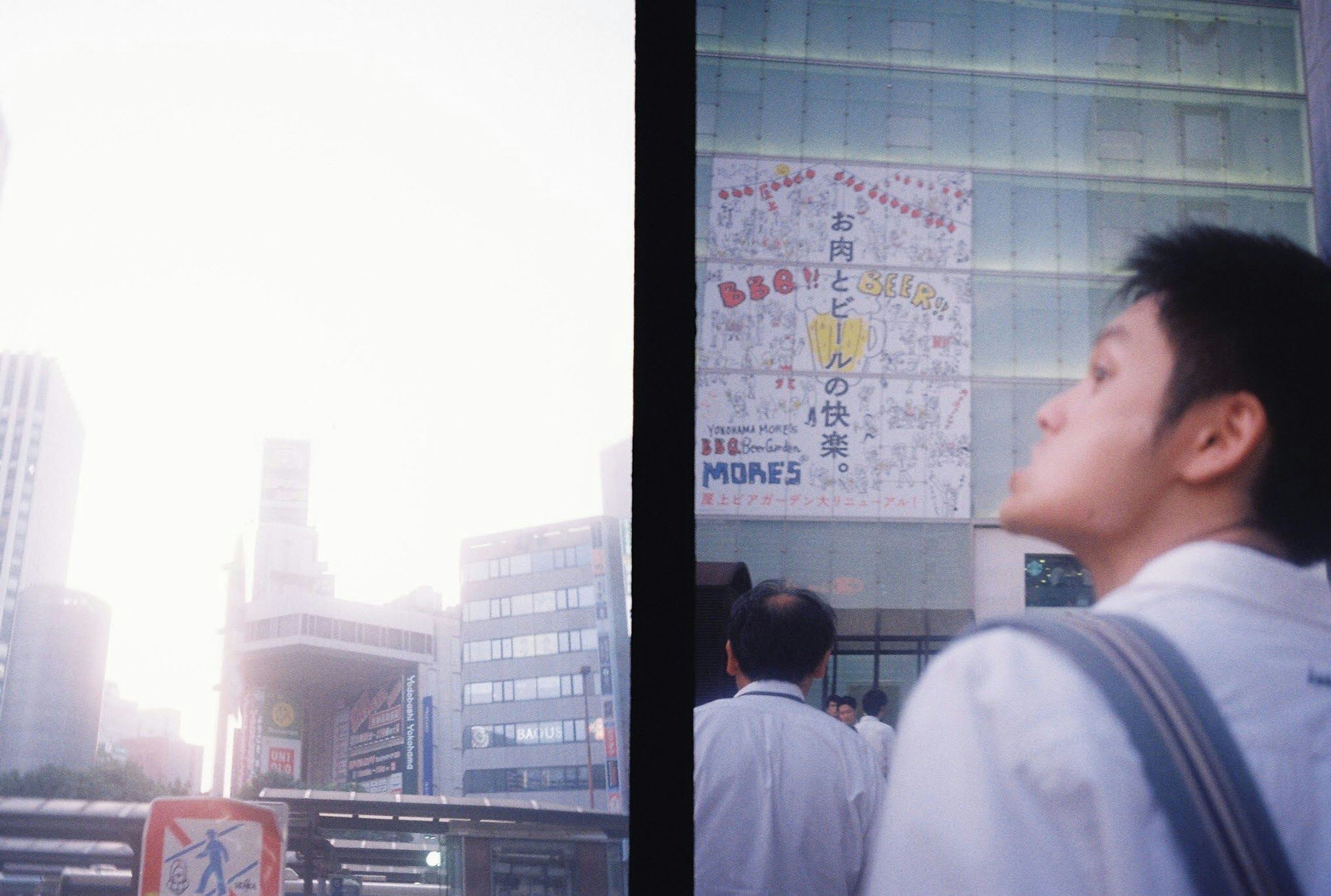 都市の景観と人々が集まる場所での夕日を背景にした男性