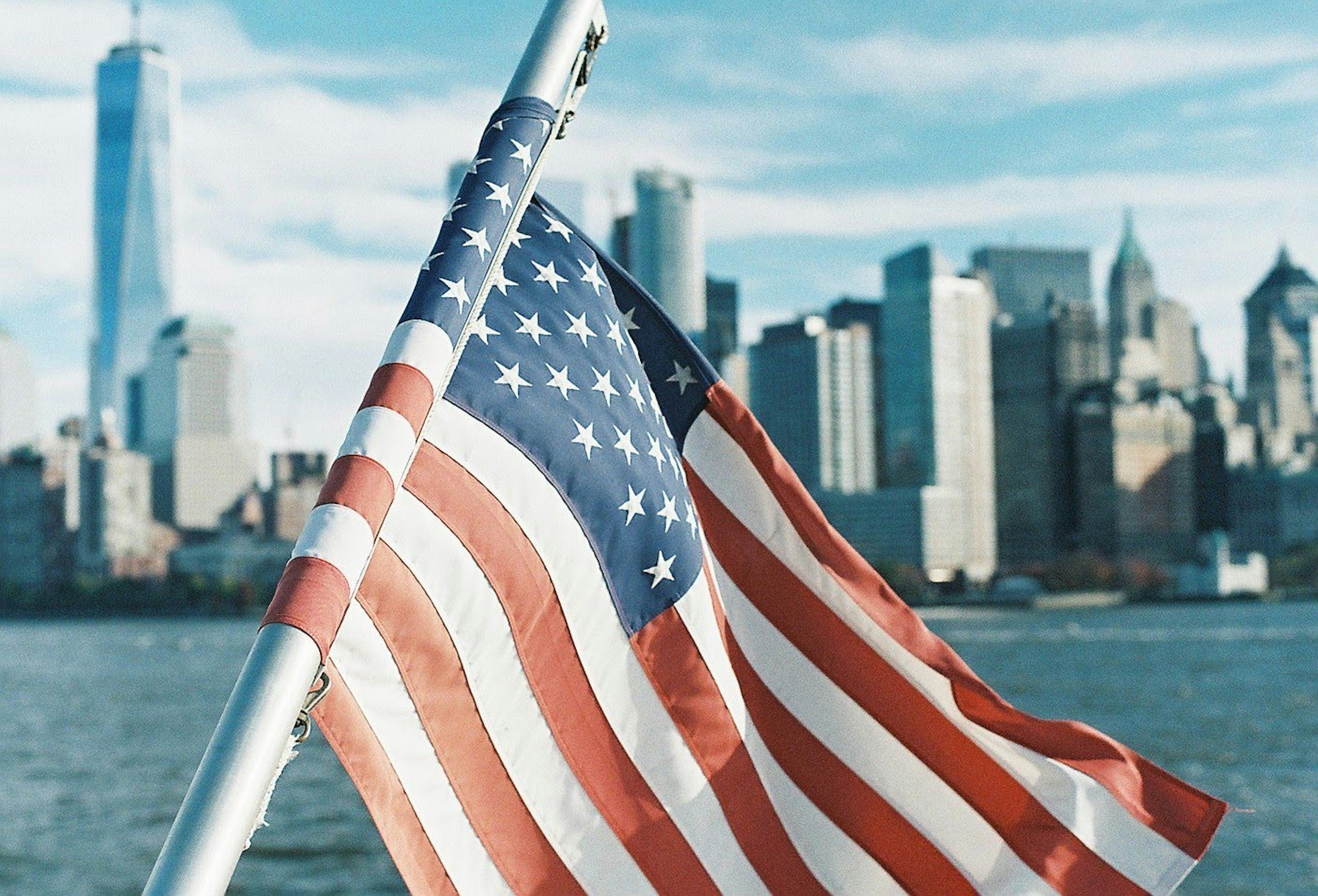 American flag waving with New York City skyline in the background