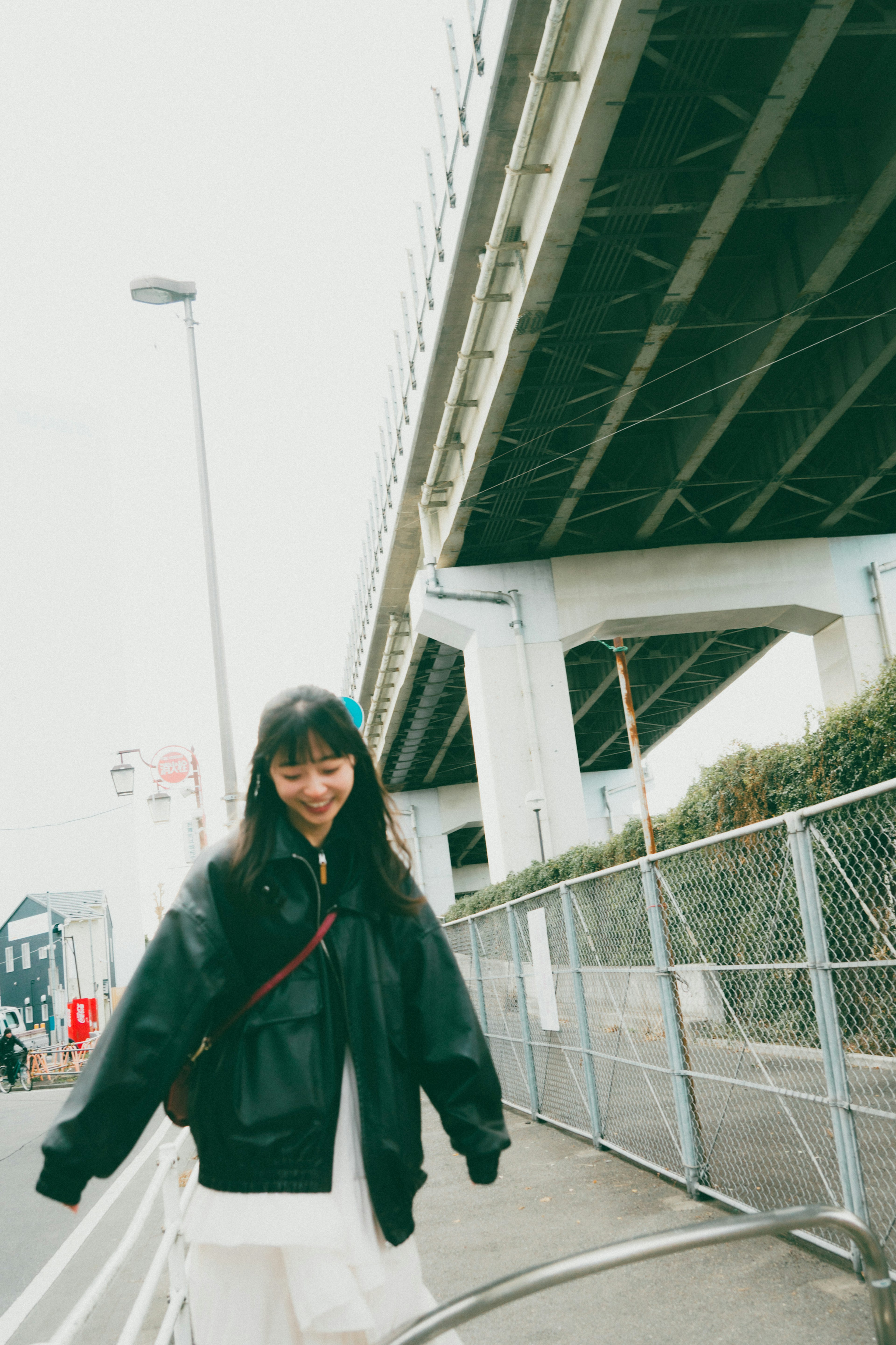 Una mujer sonriente de pie bajo un puente