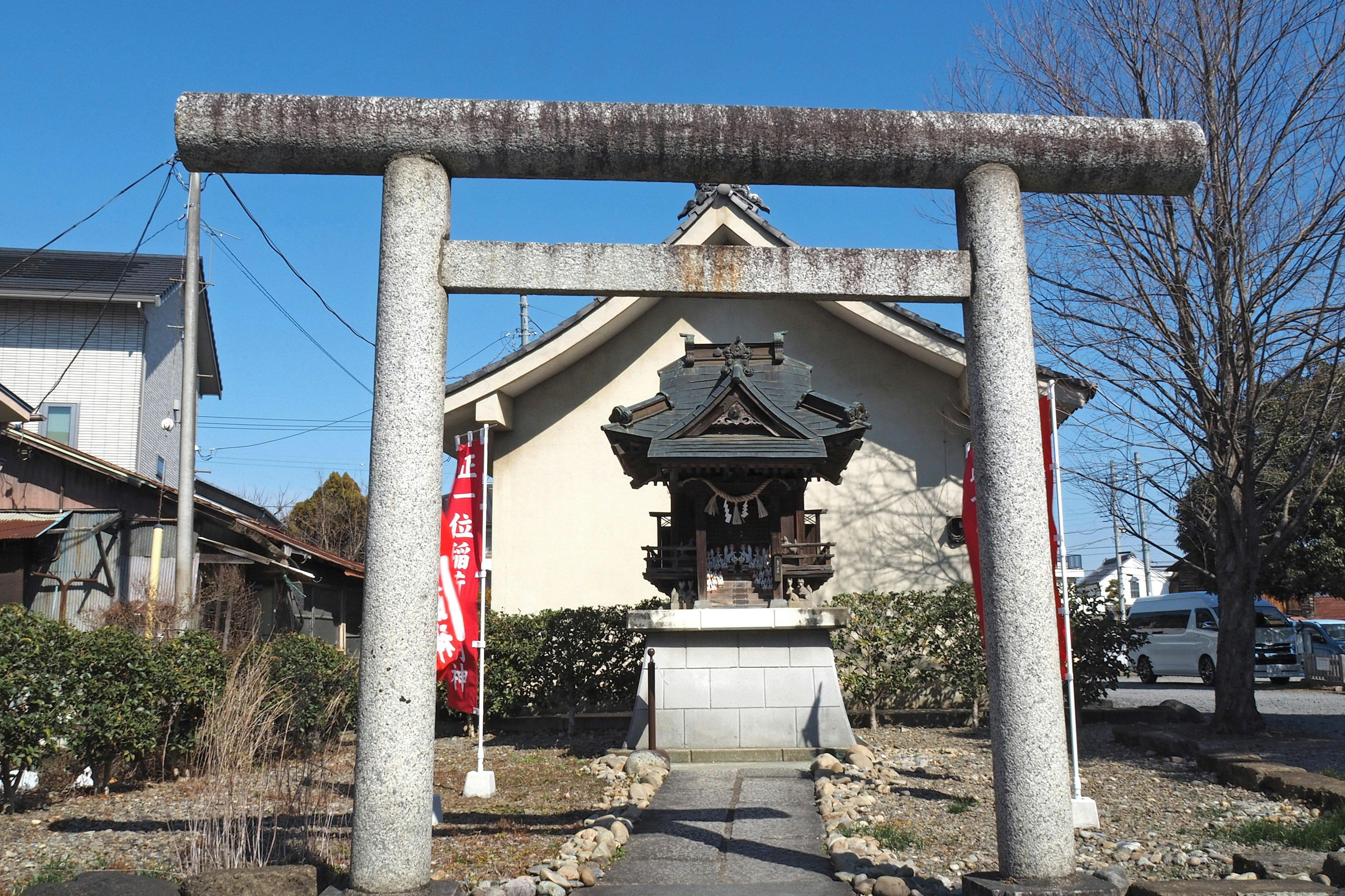 Torii-Tor vor einem Schrein unter einem klaren blauen Himmel