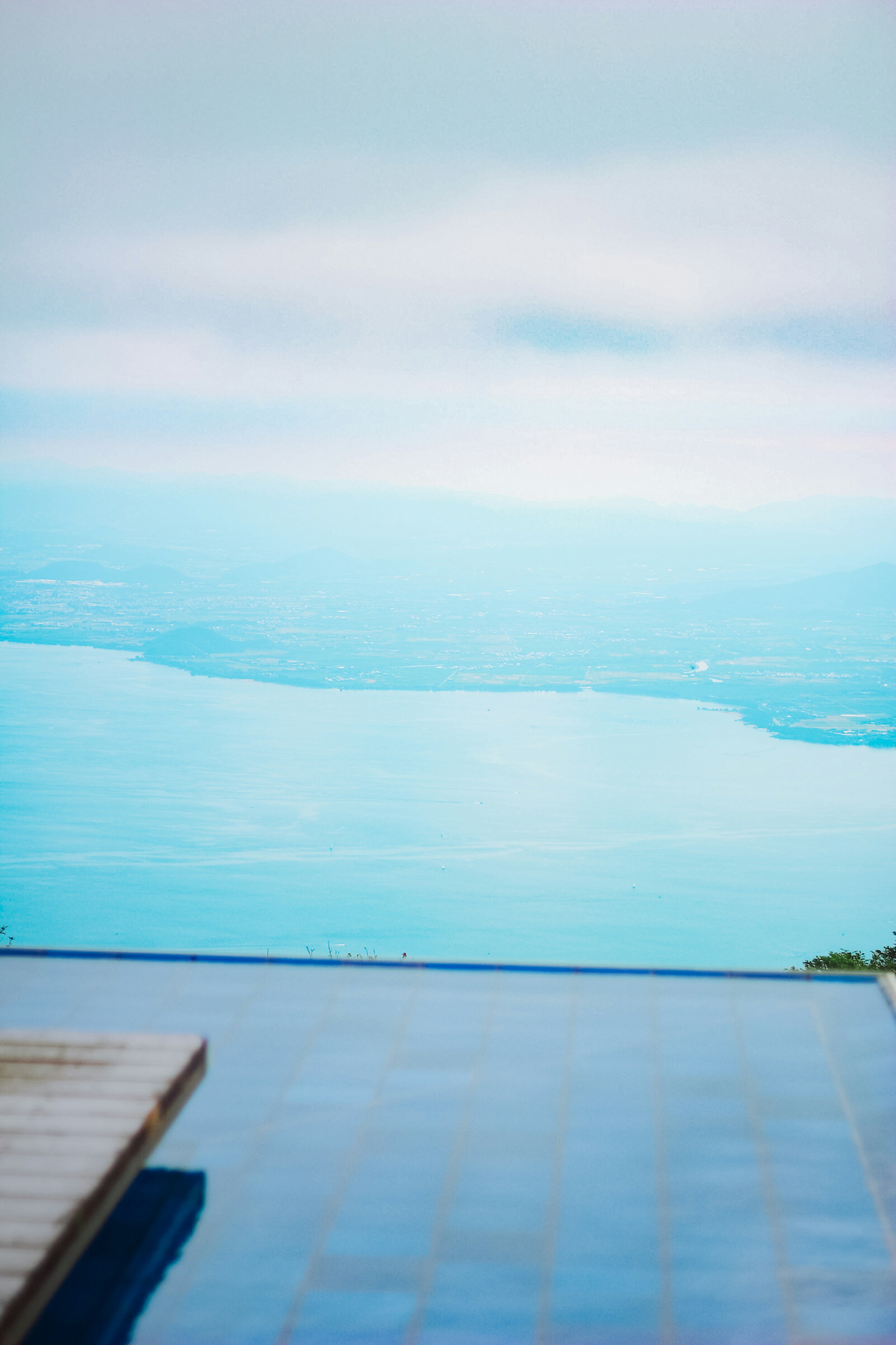 Vue pittoresque d'une piscine surplombant une surface d'eau bleue sereine et le ciel