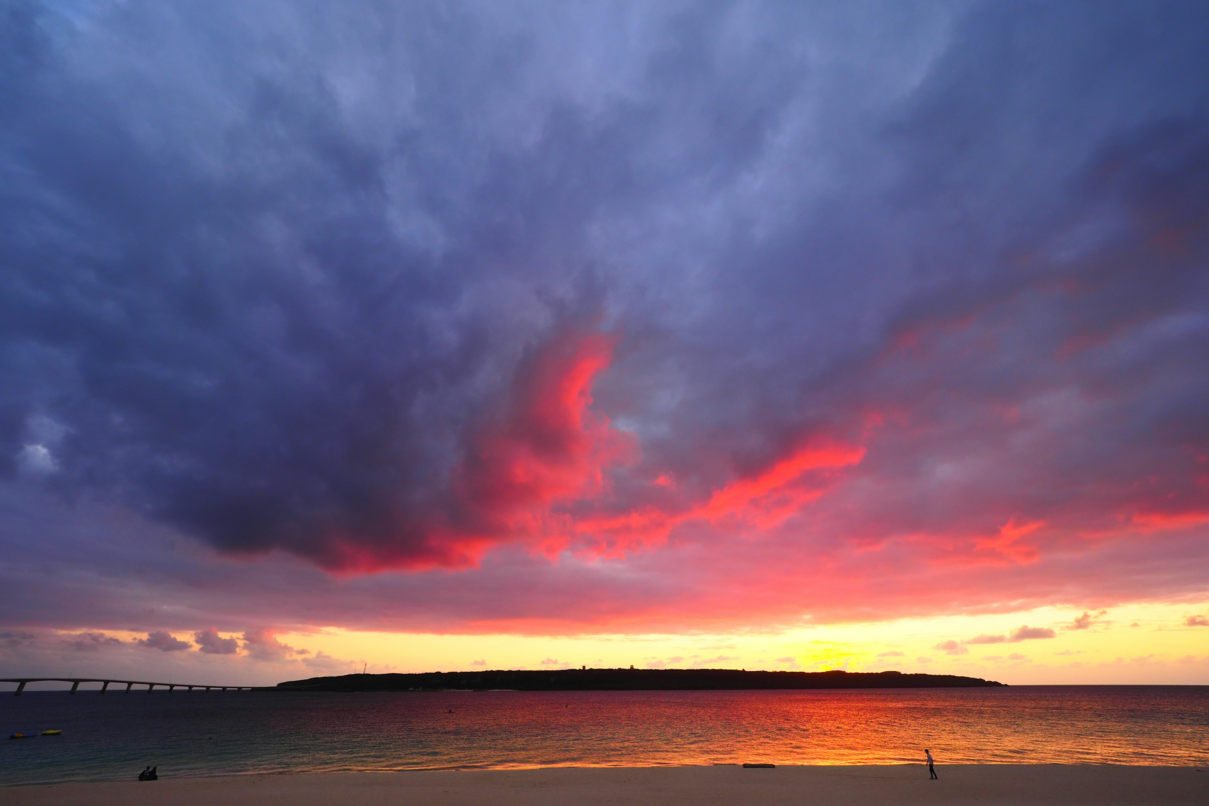 Senja yang cerah dengan awan berwarna-warni di atas laut tenang