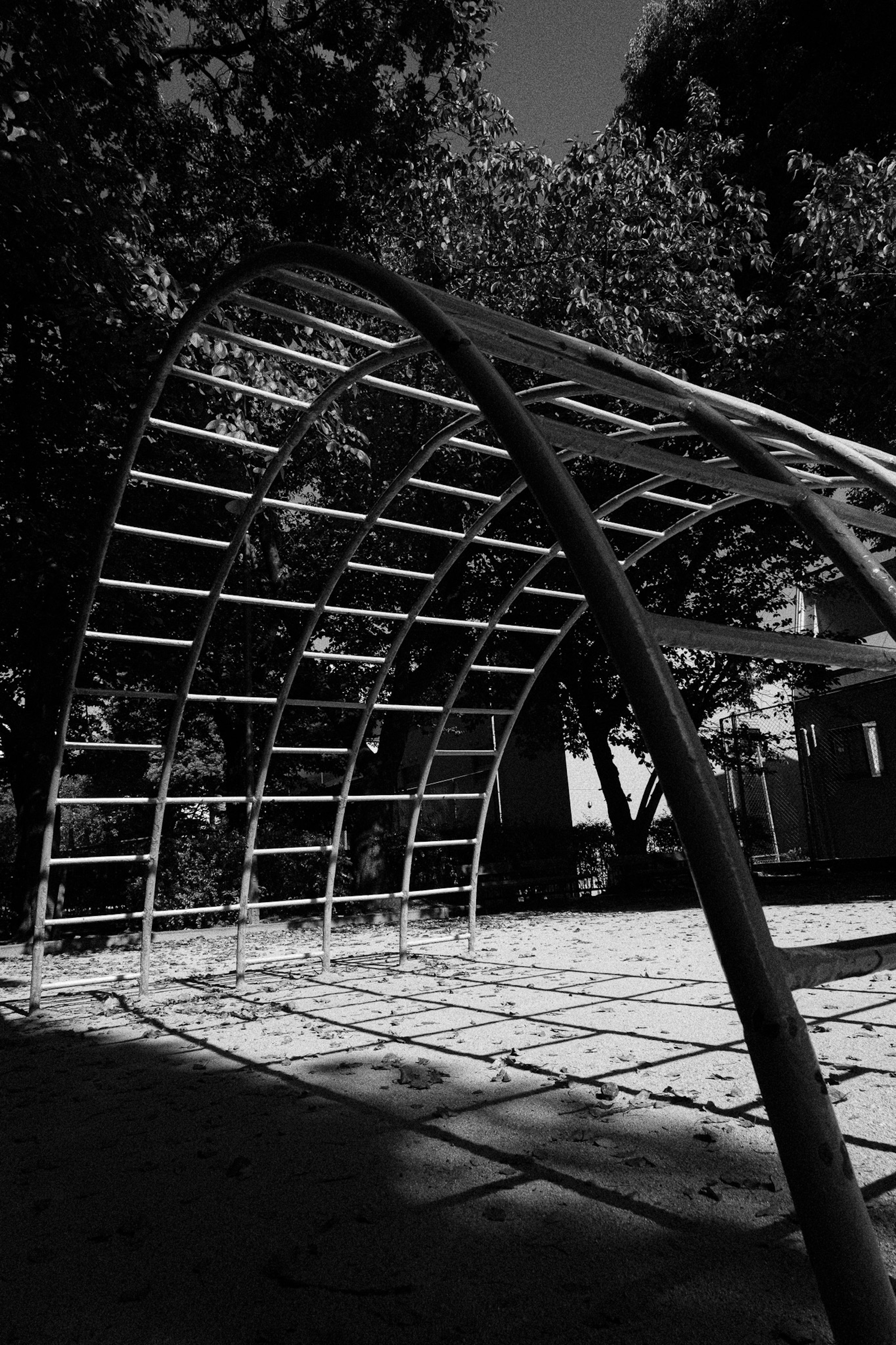 Image en noir et blanc d'une structure en arc dans un parc de jeux