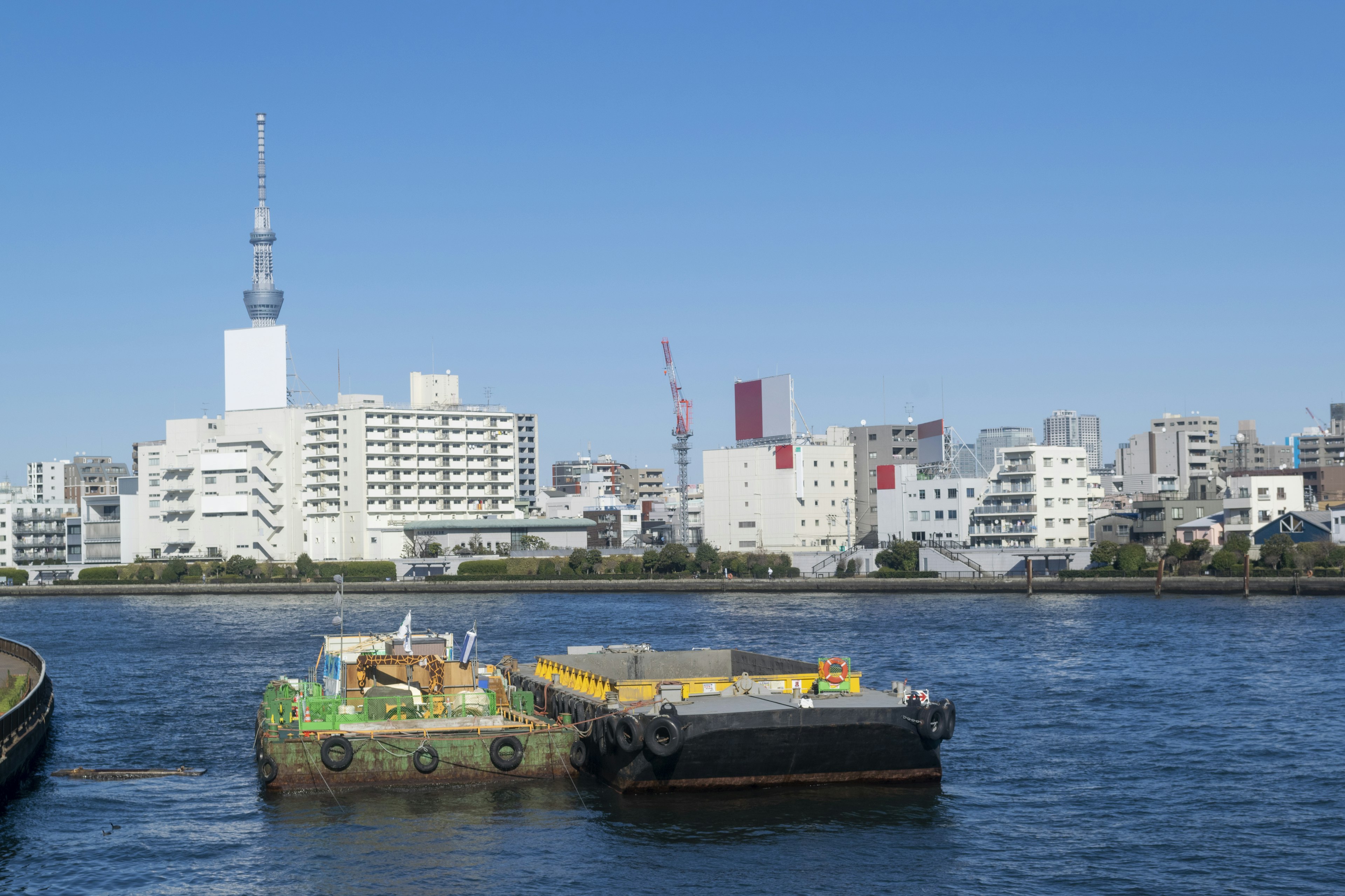 Barge flotando en un río con horizonte urbano