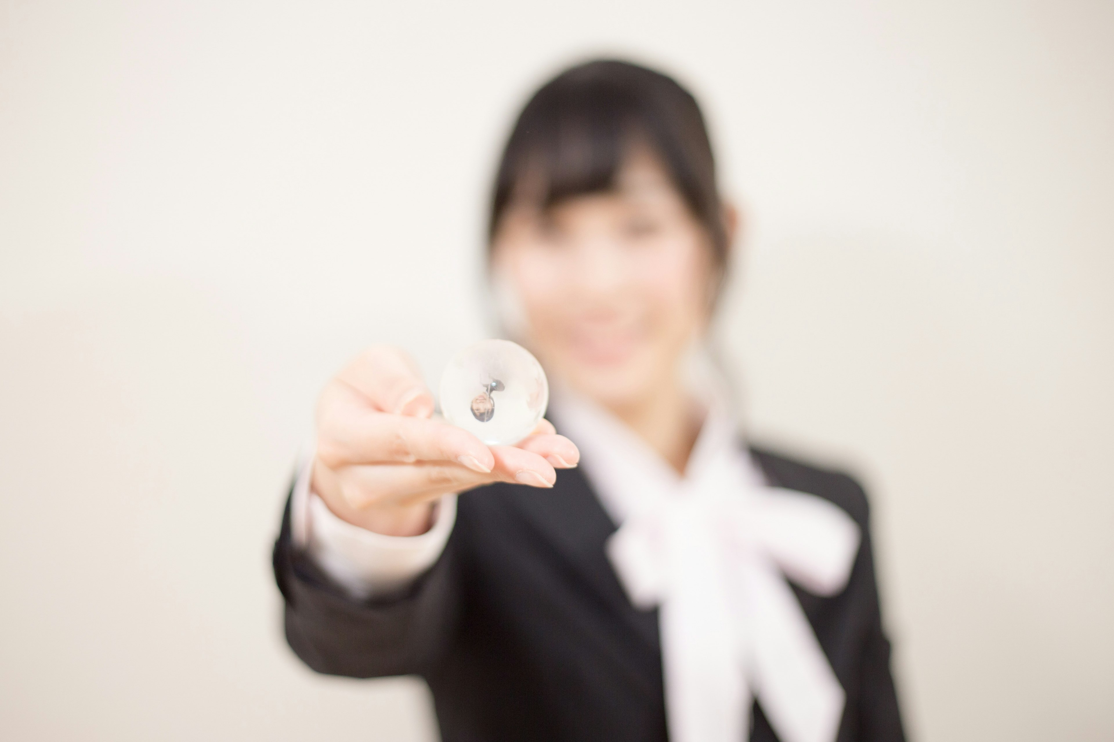 Donna in abito da lavoro che tiene un piccolo oggetto nella mano