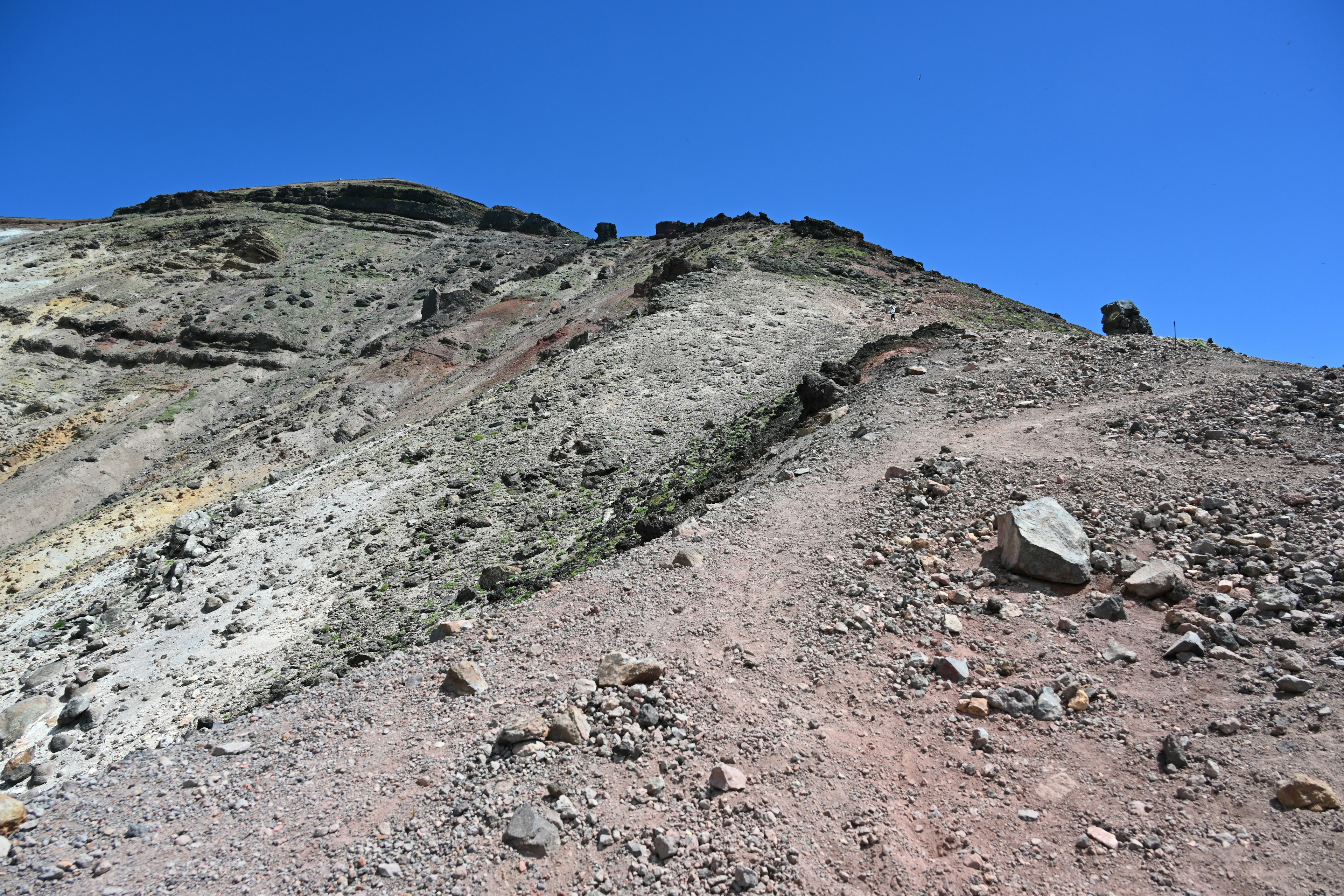 A rocky mountain slope under a clear blue sky