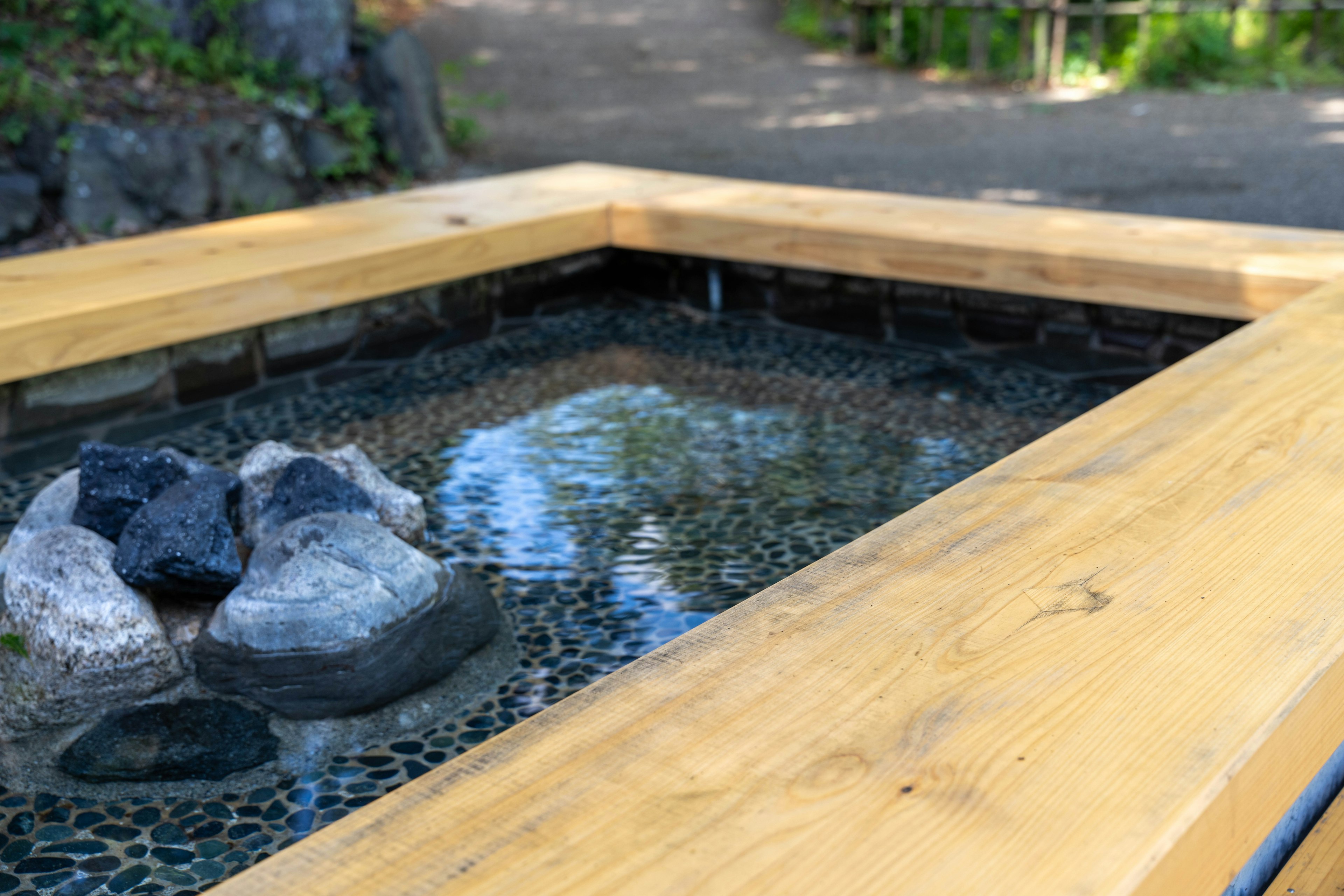 Una fuente de madera con piedras en su interior