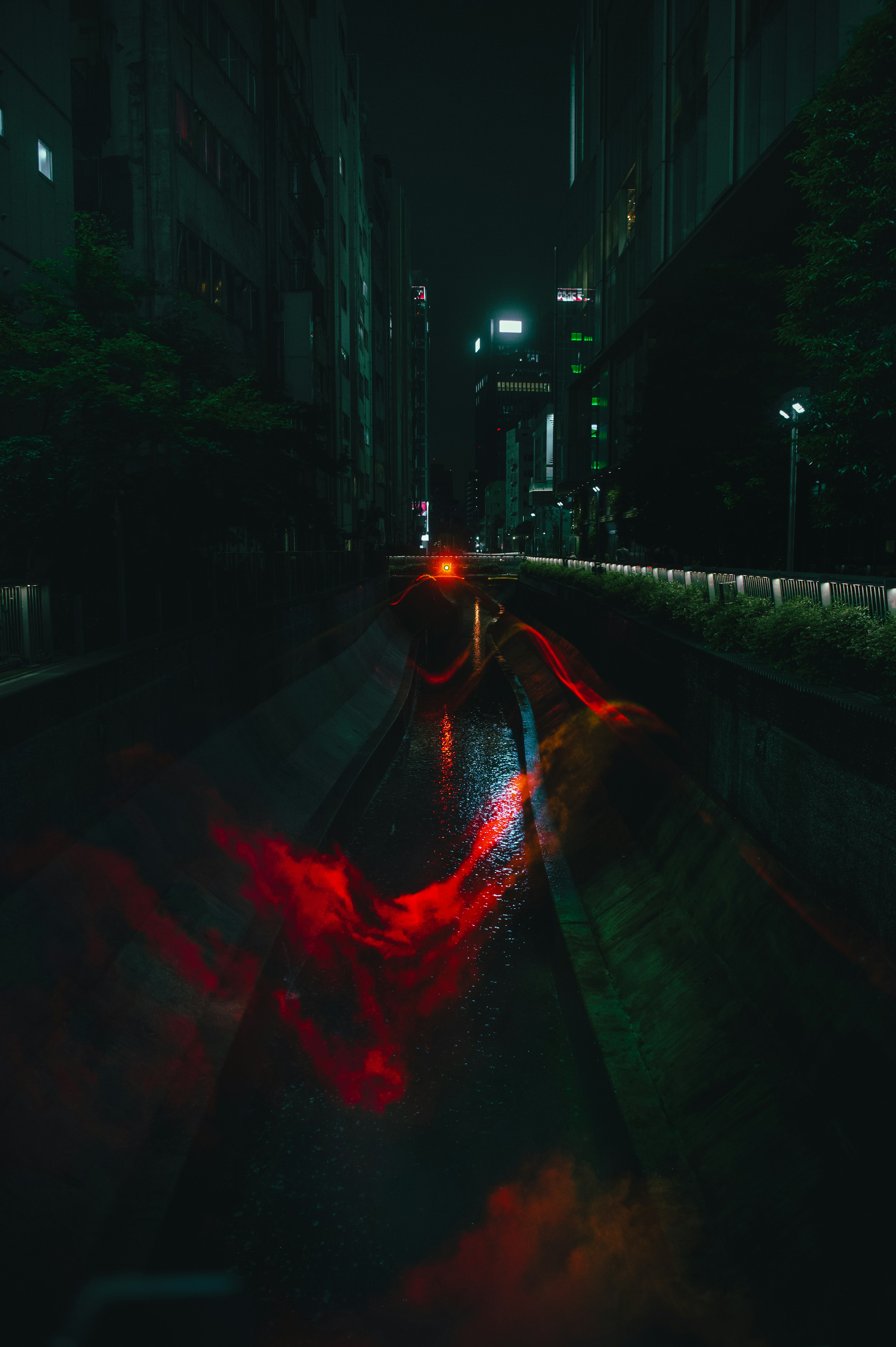 Reflections of red and green lights on a dark city street