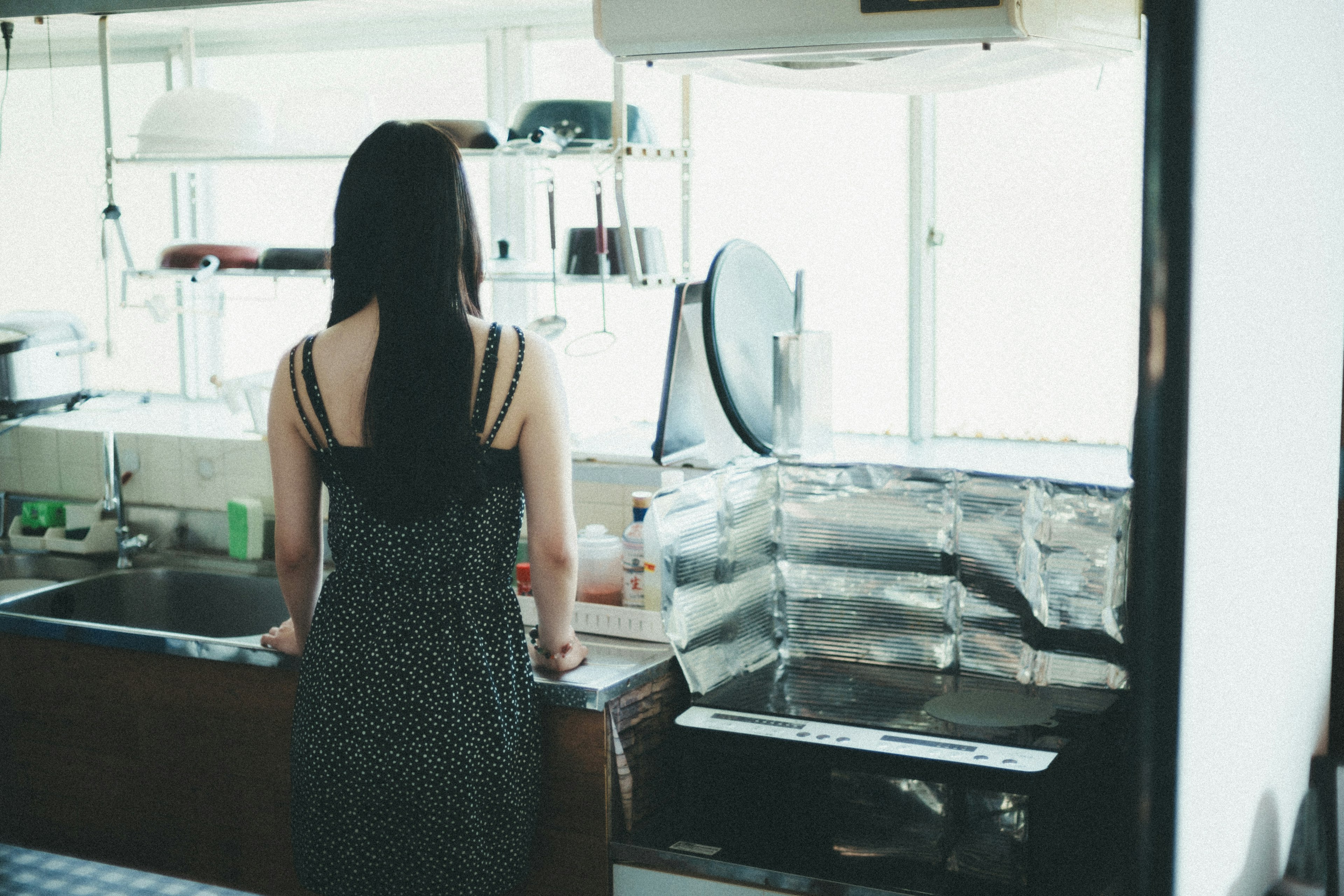 Una donna in piedi in una cucina di spalle