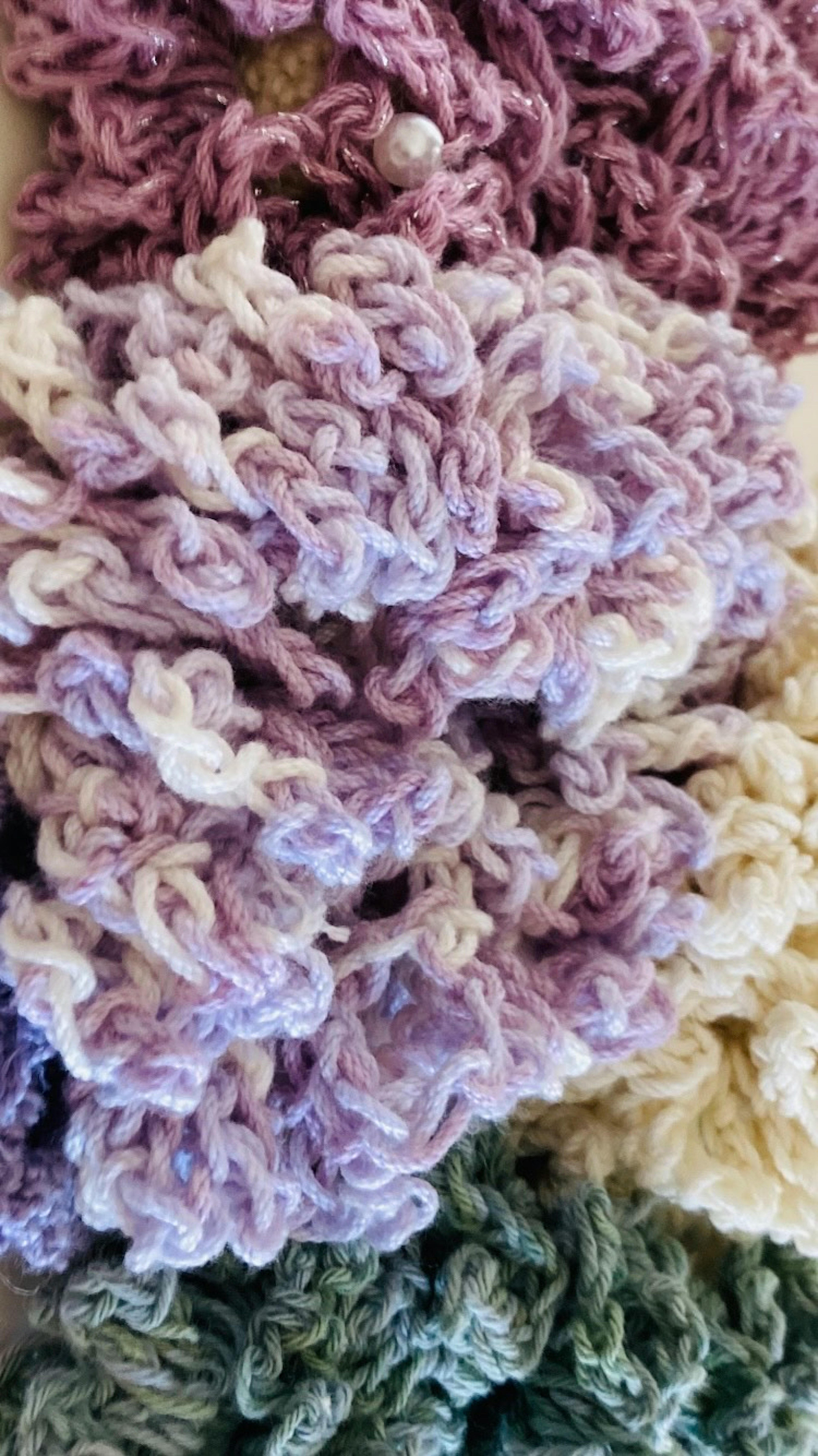 Close-up of textured yarn in pastel colors including purple and green