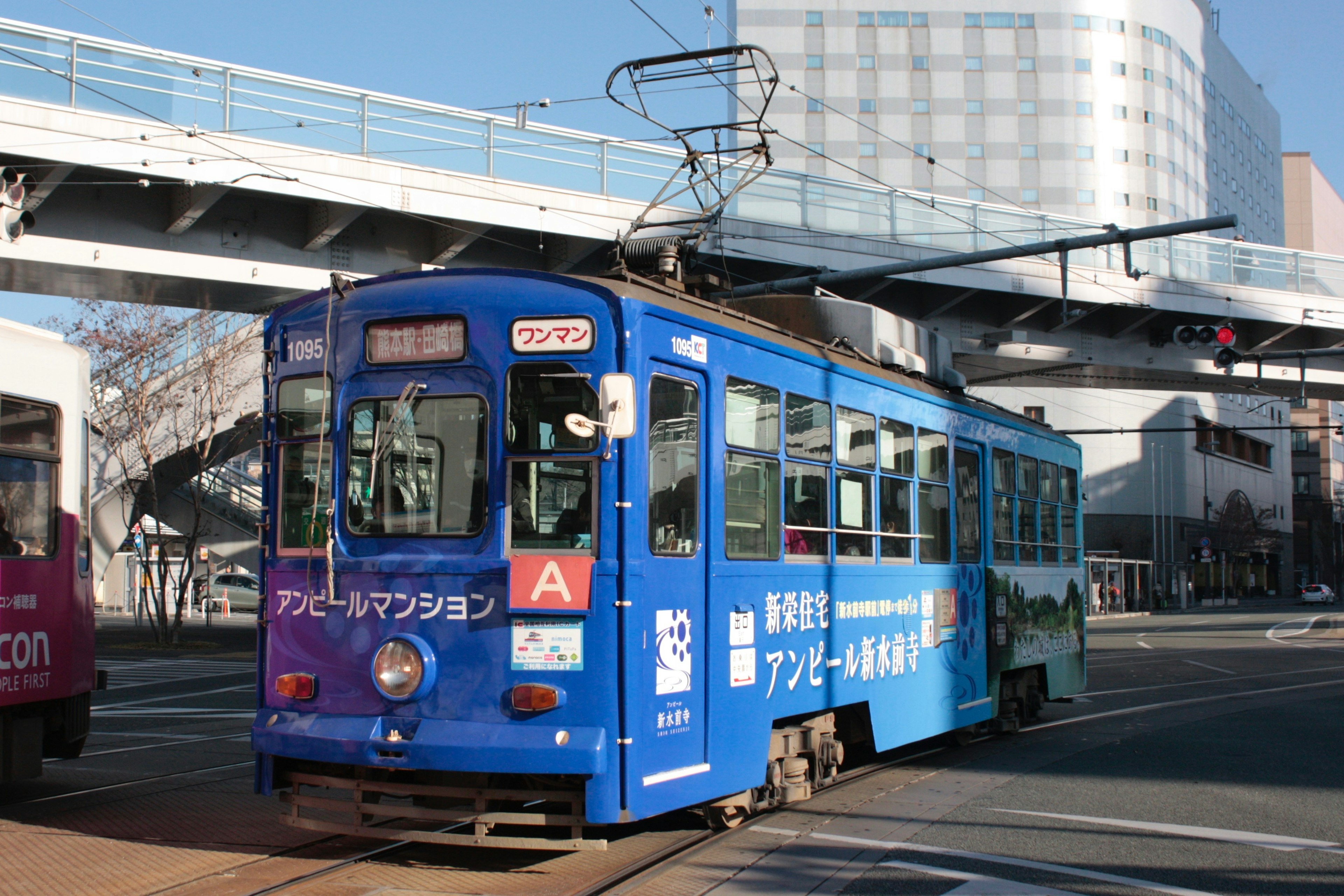 Eine blaue Straßenbahn, die durch die Stadt fährt