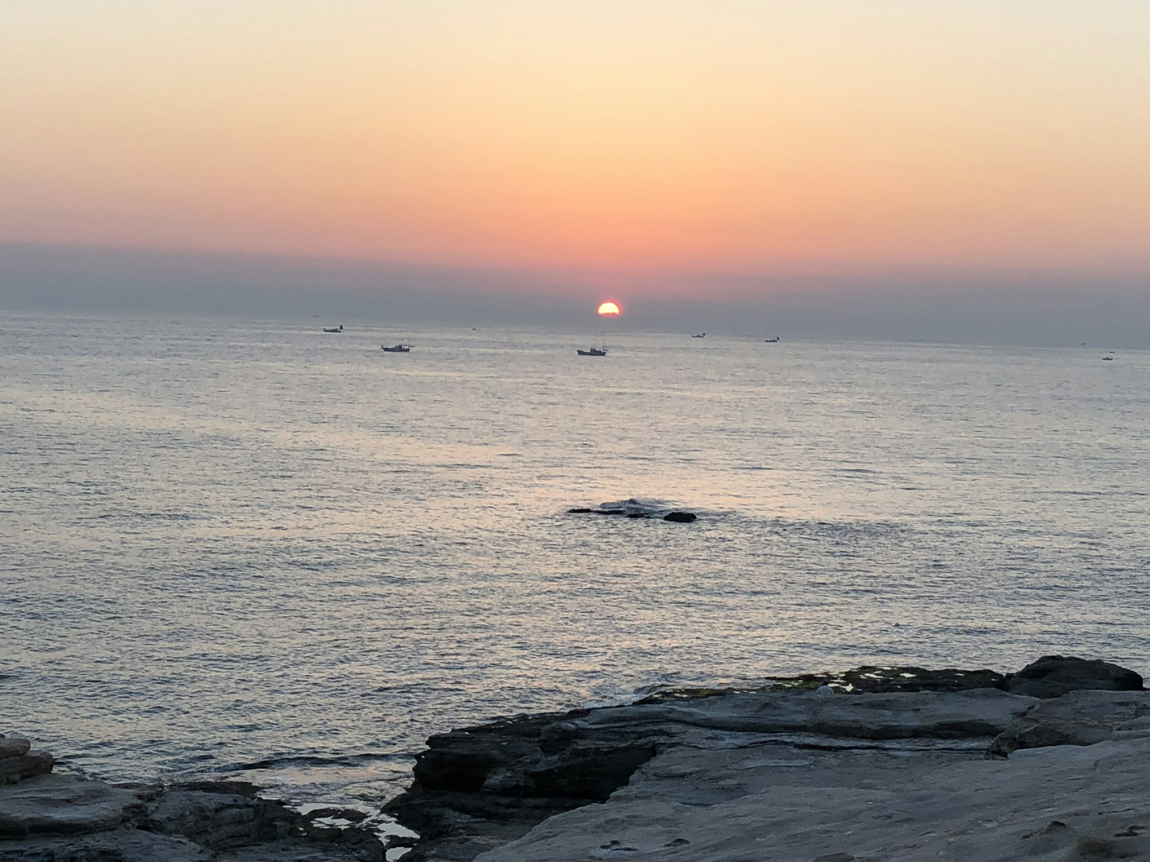 海に沈む夕日と穏やかな波の景色