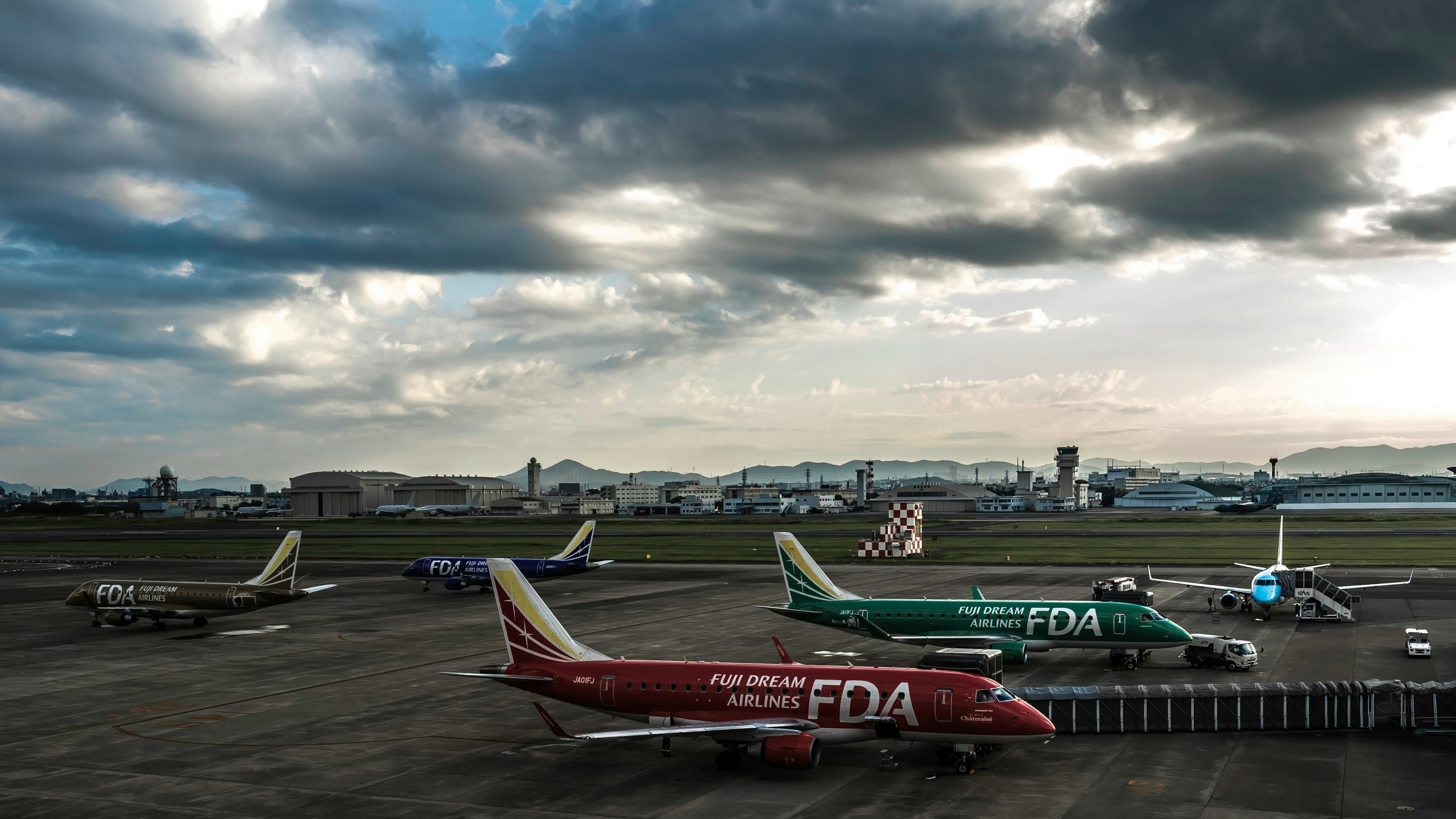 多架飛機停靠在機場，天空多雲