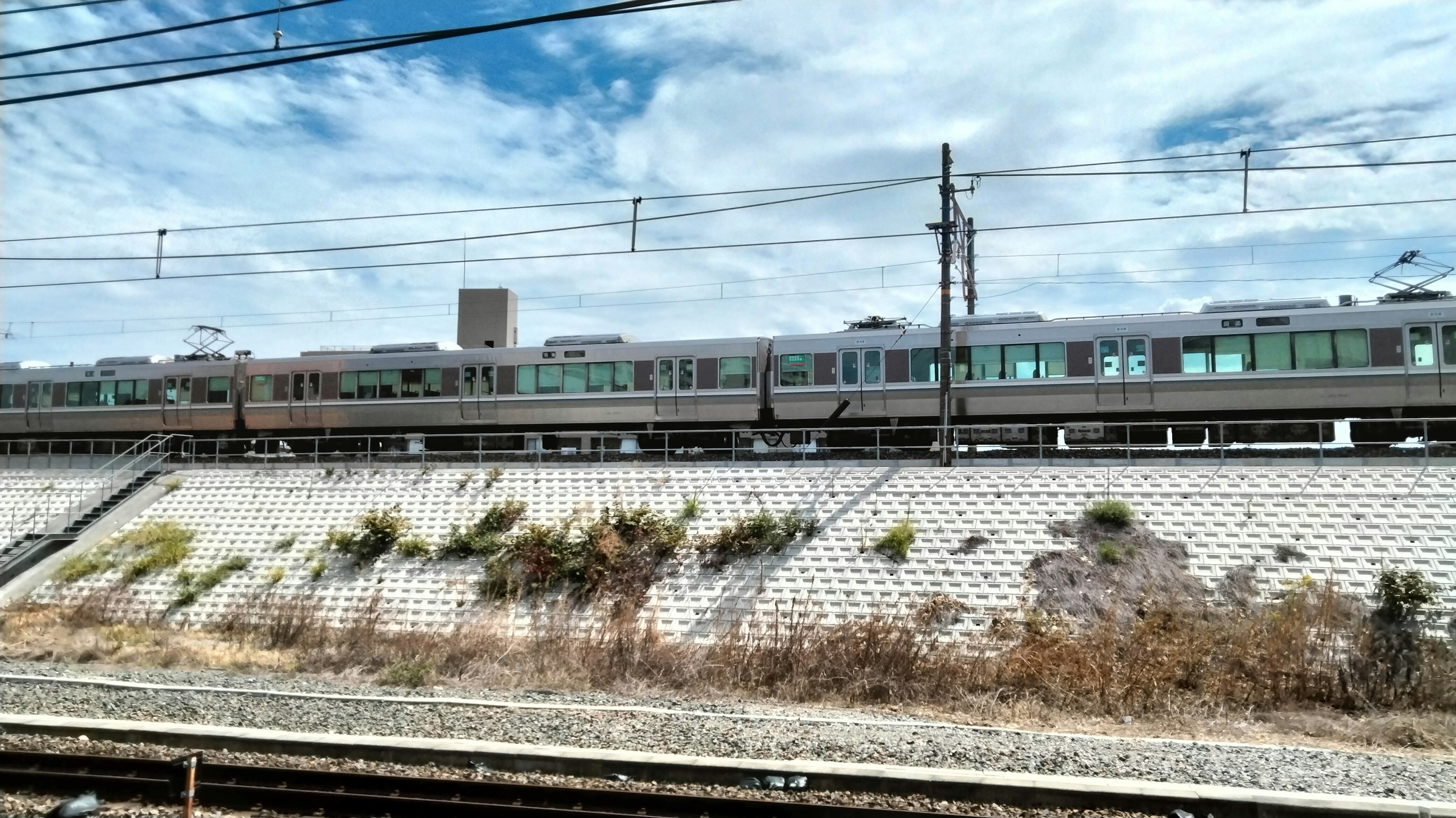 Treno che corre lungo i binari con cielo blu