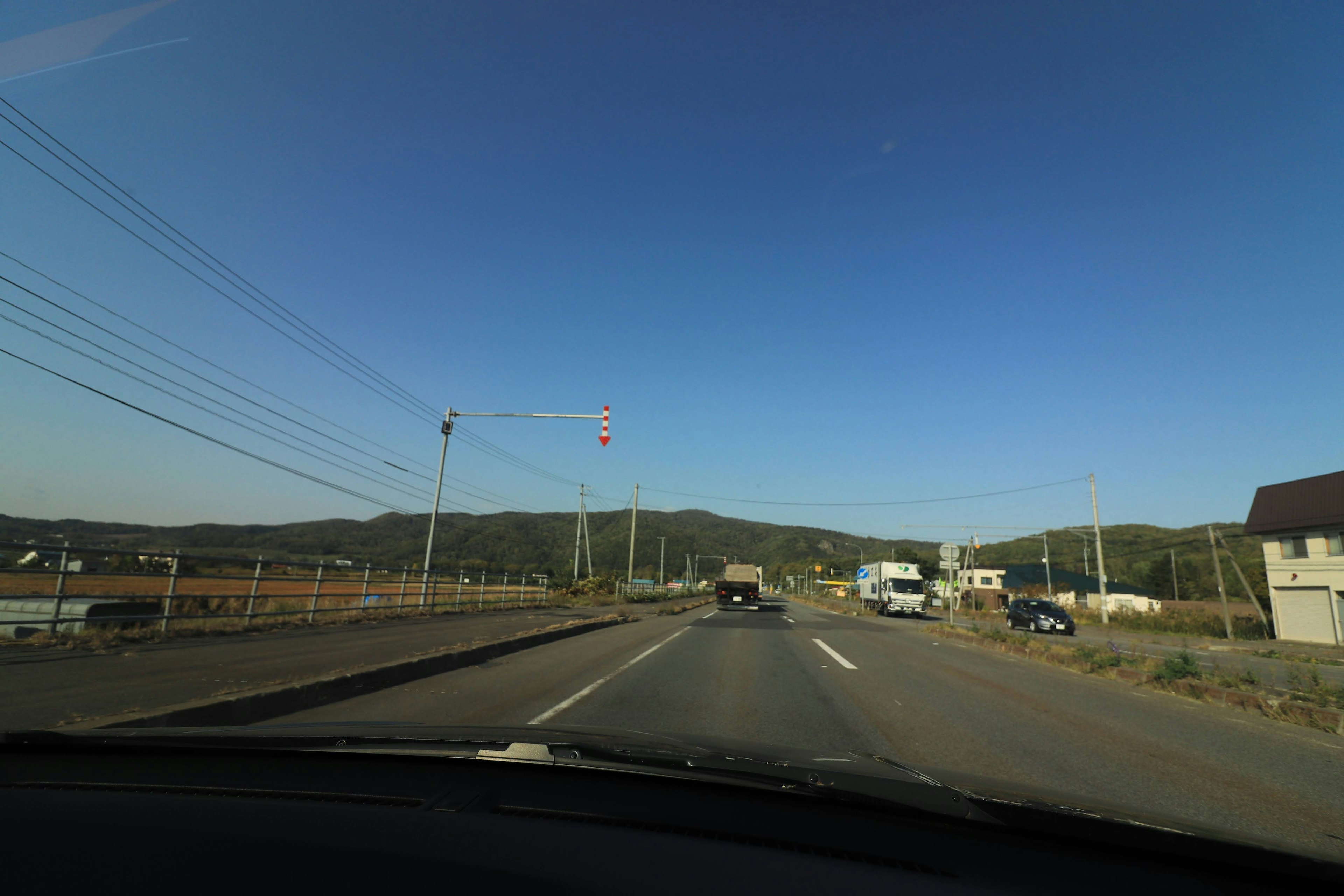 Vista de carretera con cielo azul y montañas al fondo