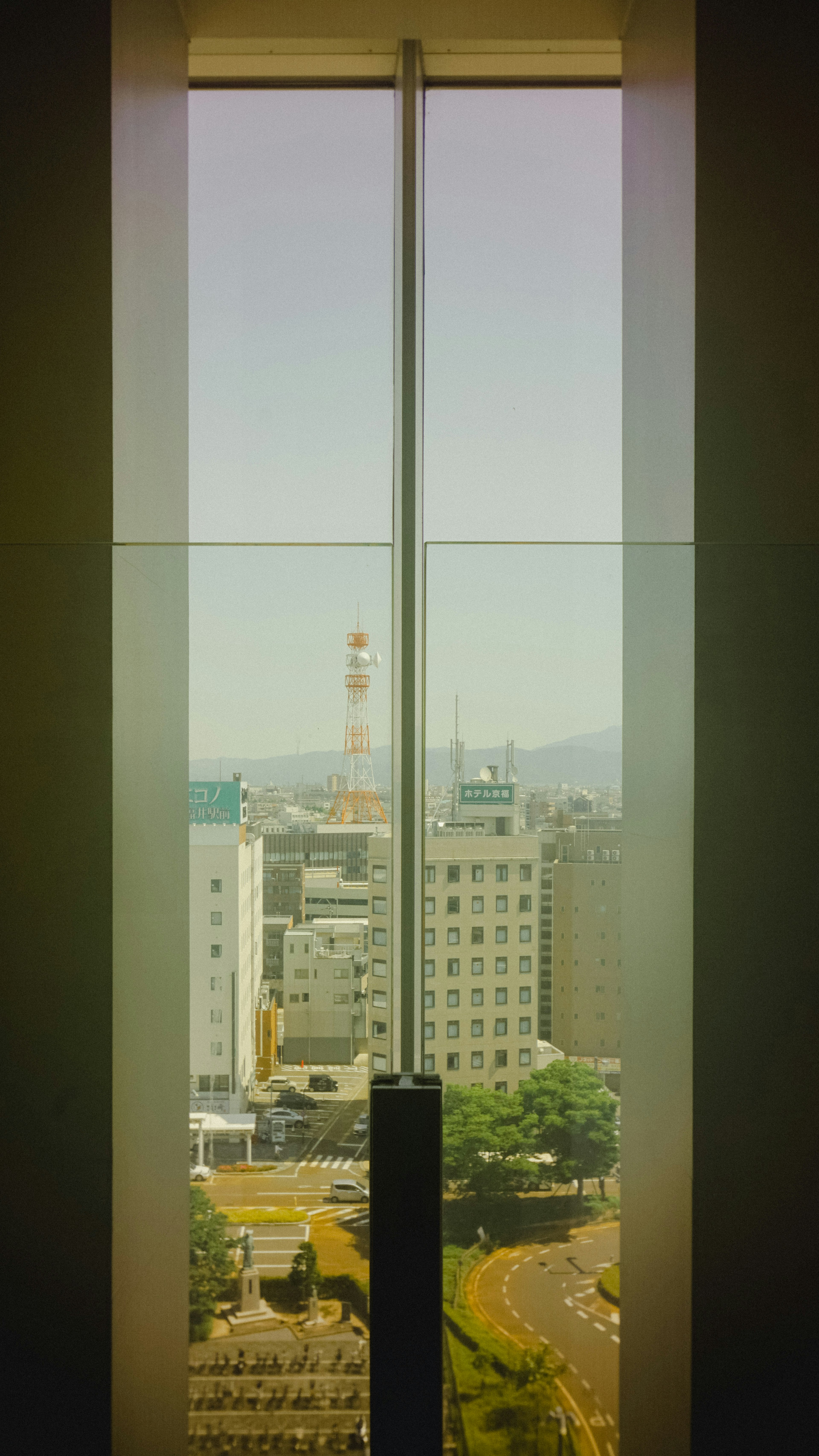 高層ビルの窓から見える都市の風景と明るい空