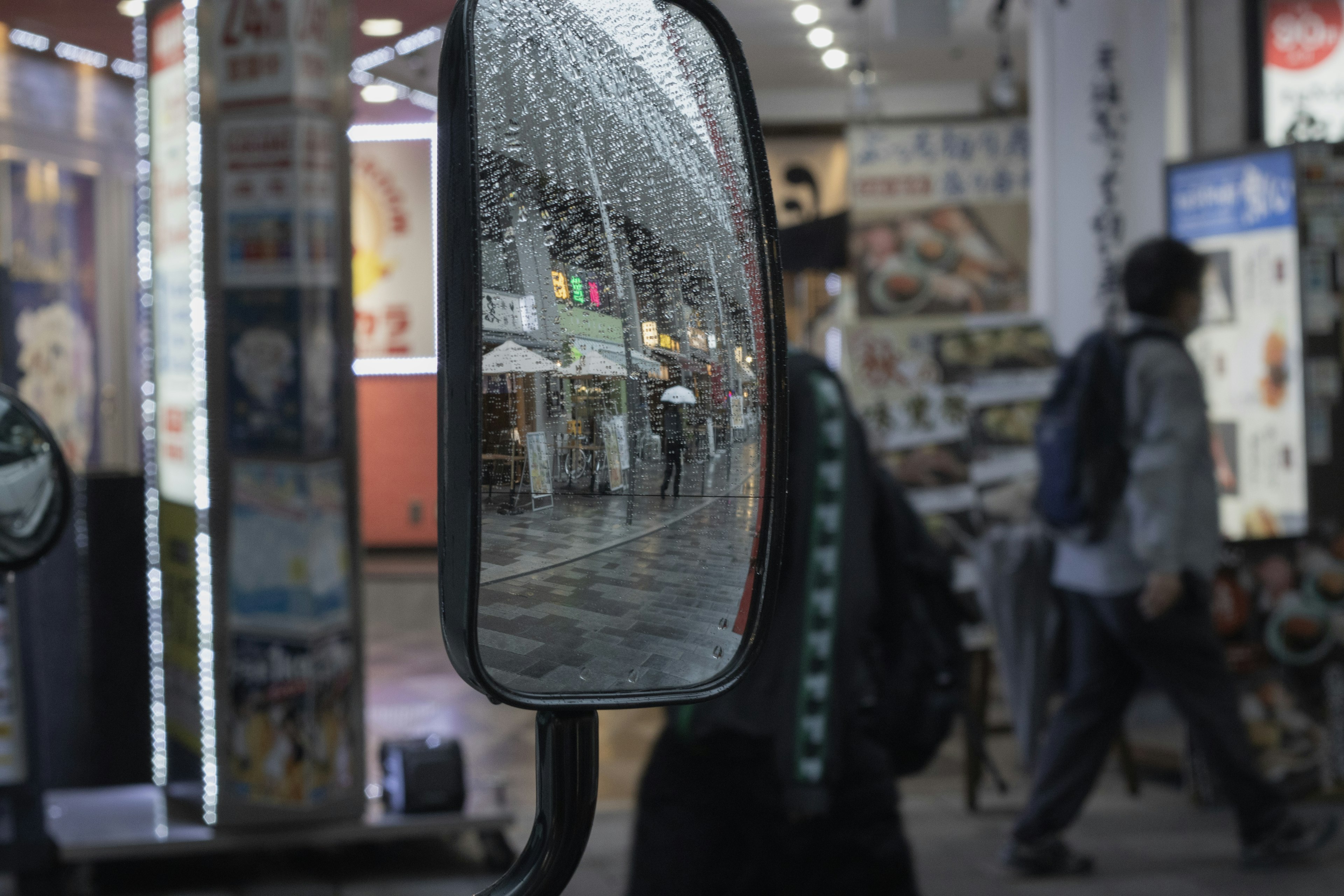 鏡に映る商店街の風景と歩行者の姿