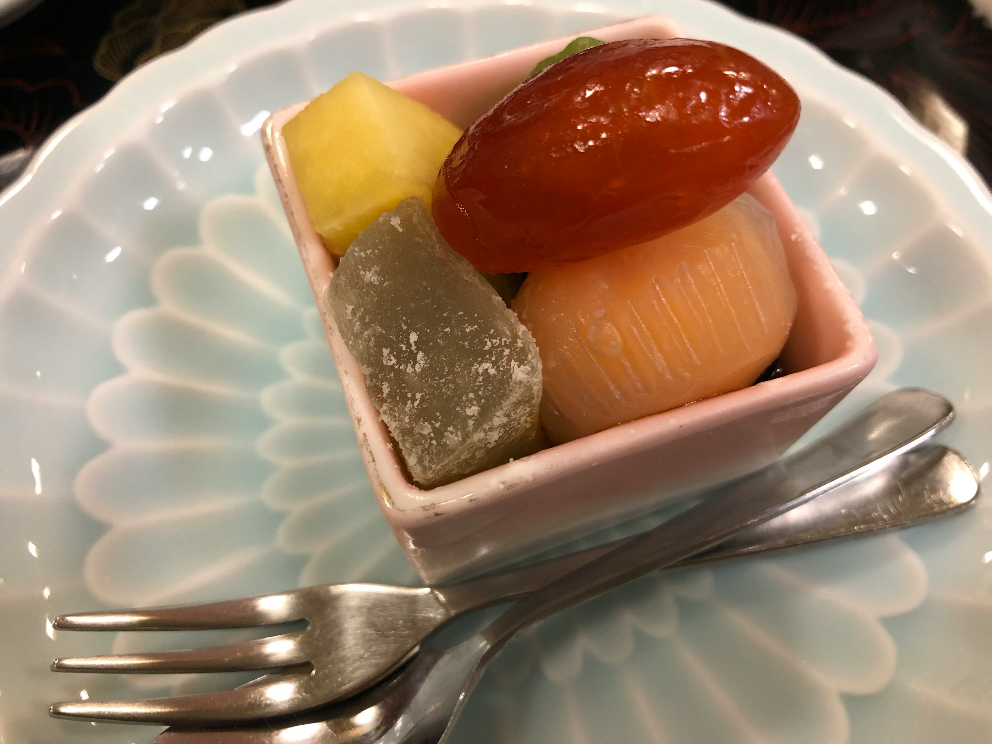 小さなピンクの容器に盛られた色とりどりの和菓子とフルーツ