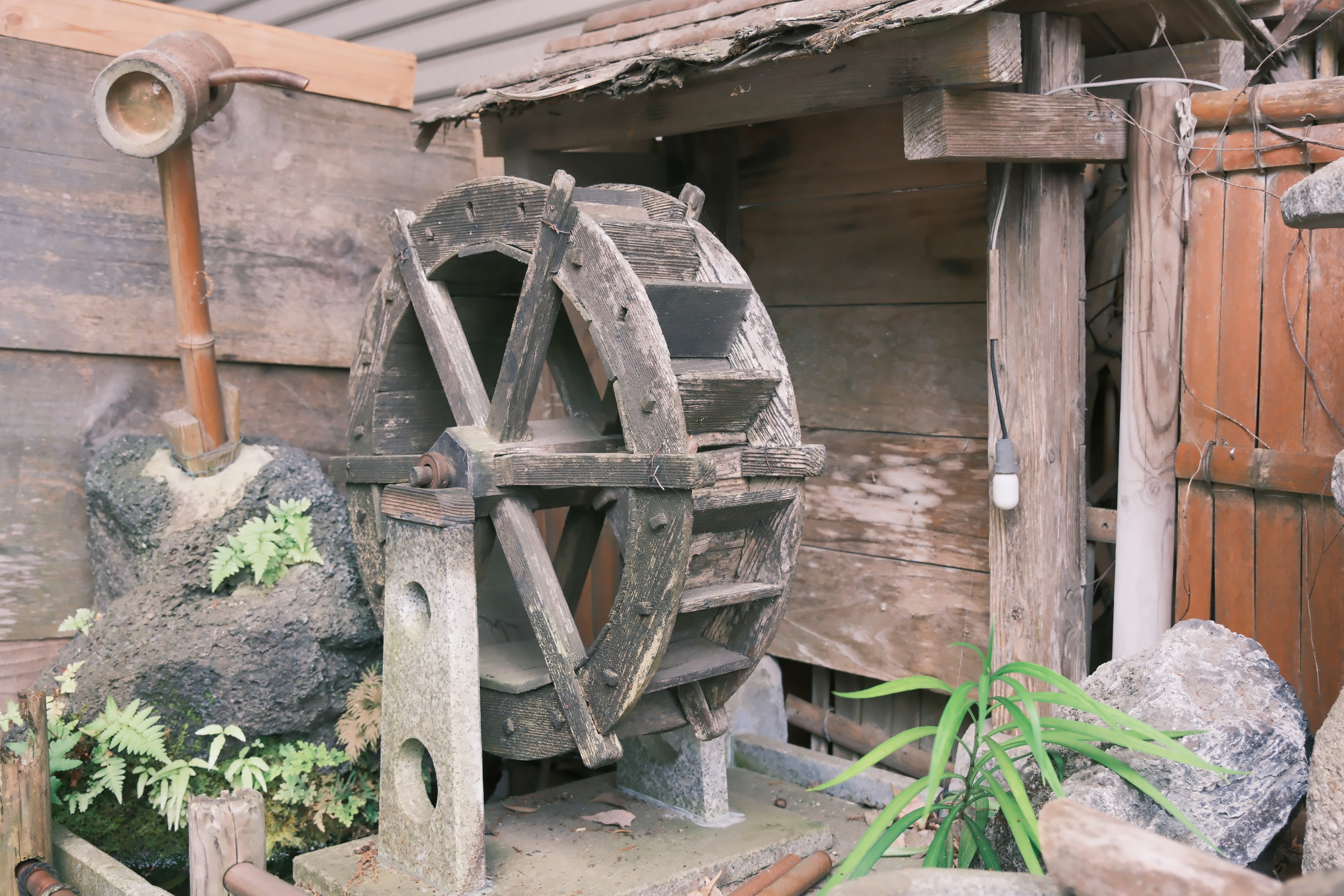 An old water wheel set against a wooden background