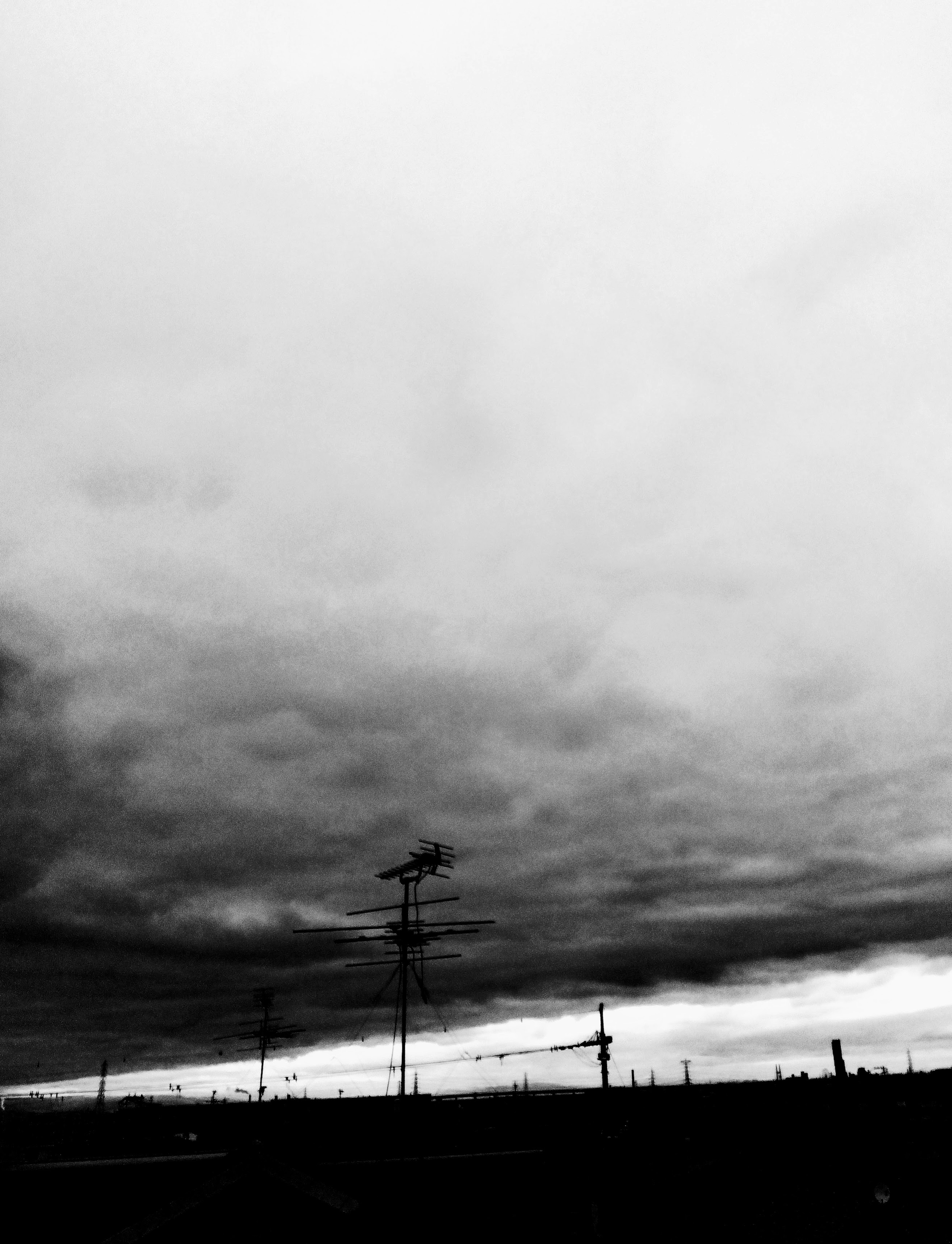 Dunkle Wolken mit Stromleitungen im Vordergrund