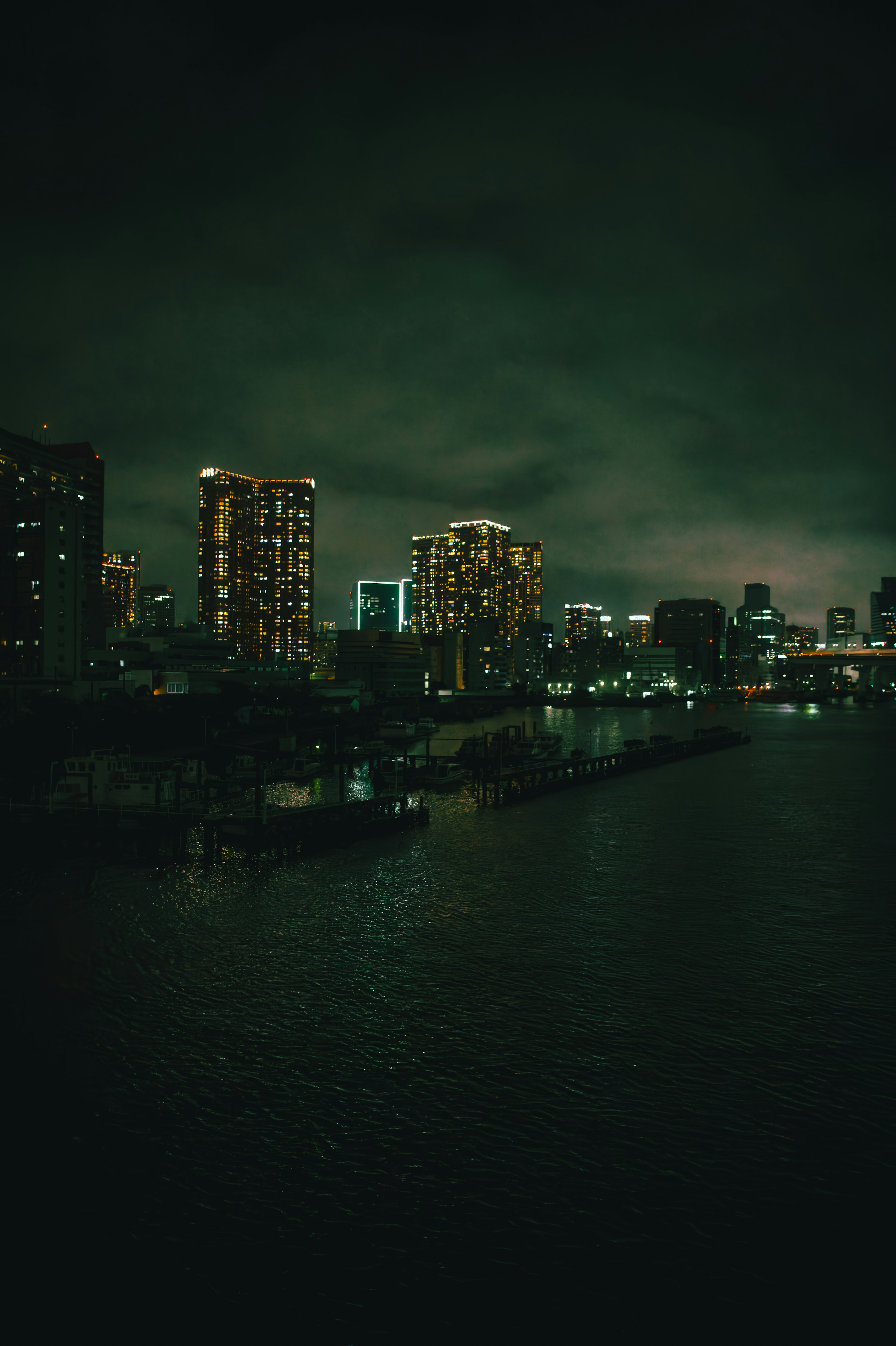 Night cityscape featuring skyscrapers and river reflection