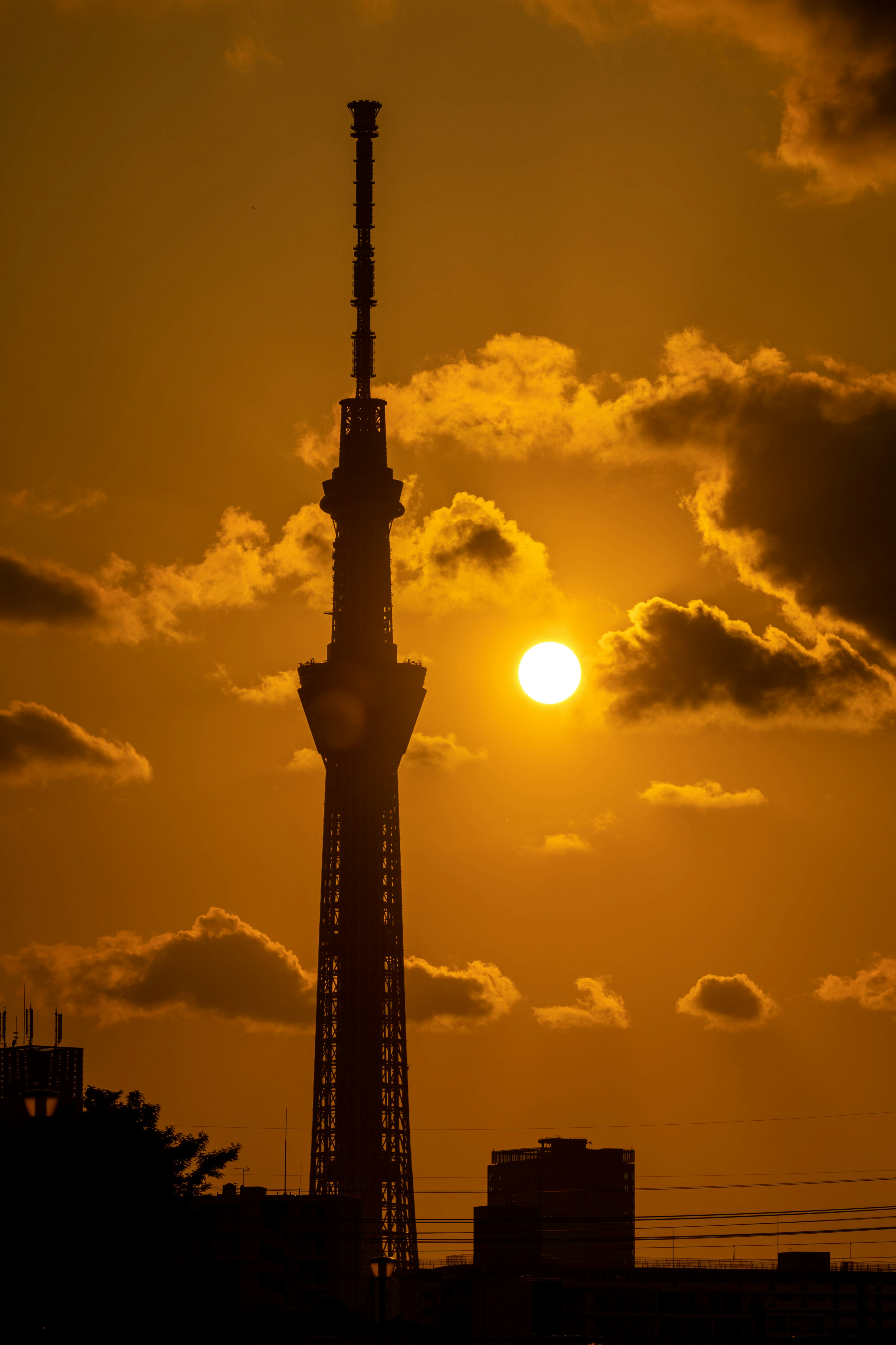 Silhouette de la Tokyo Skytree contra un vibrante atardecer con nubes