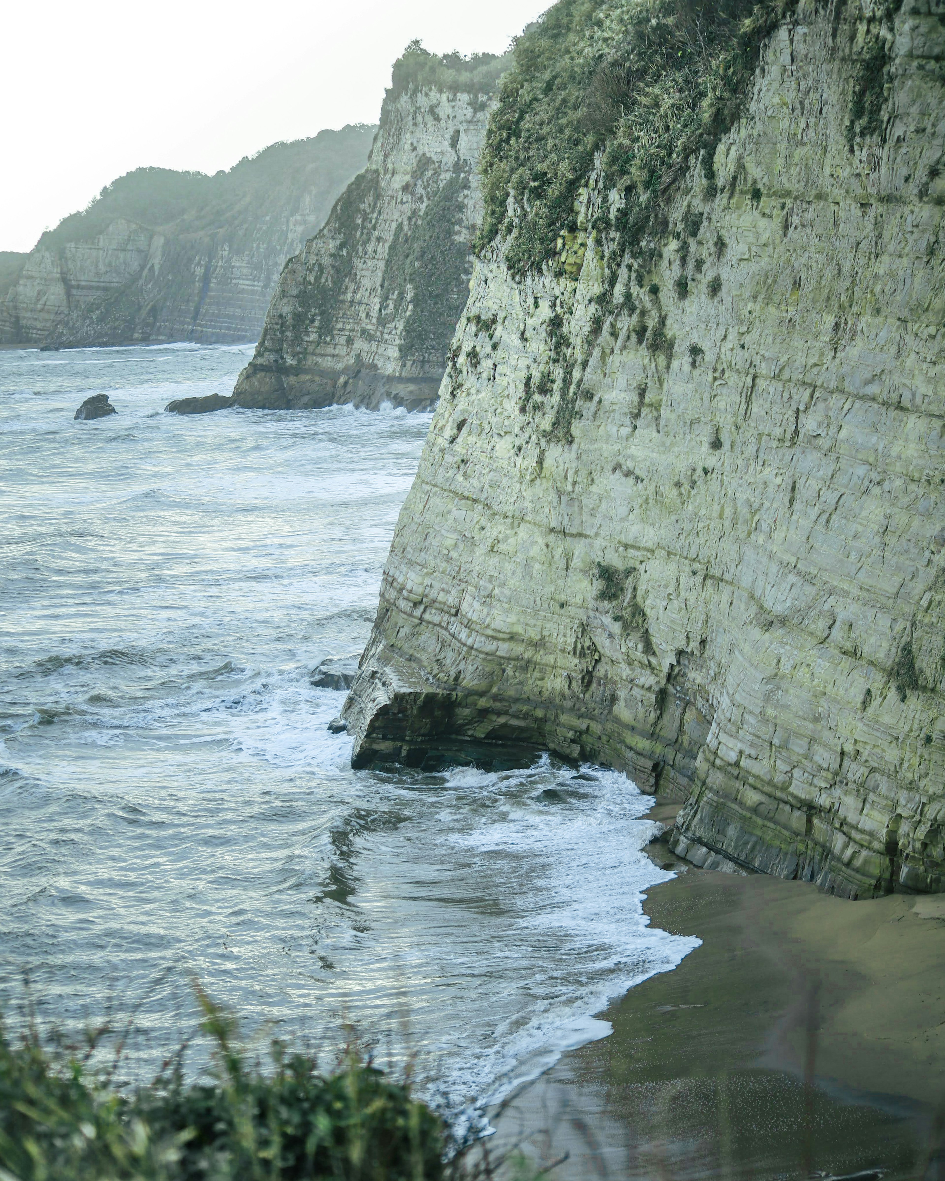 Paysage de falaise côtière avec des roches en couches et des vagues océaniques