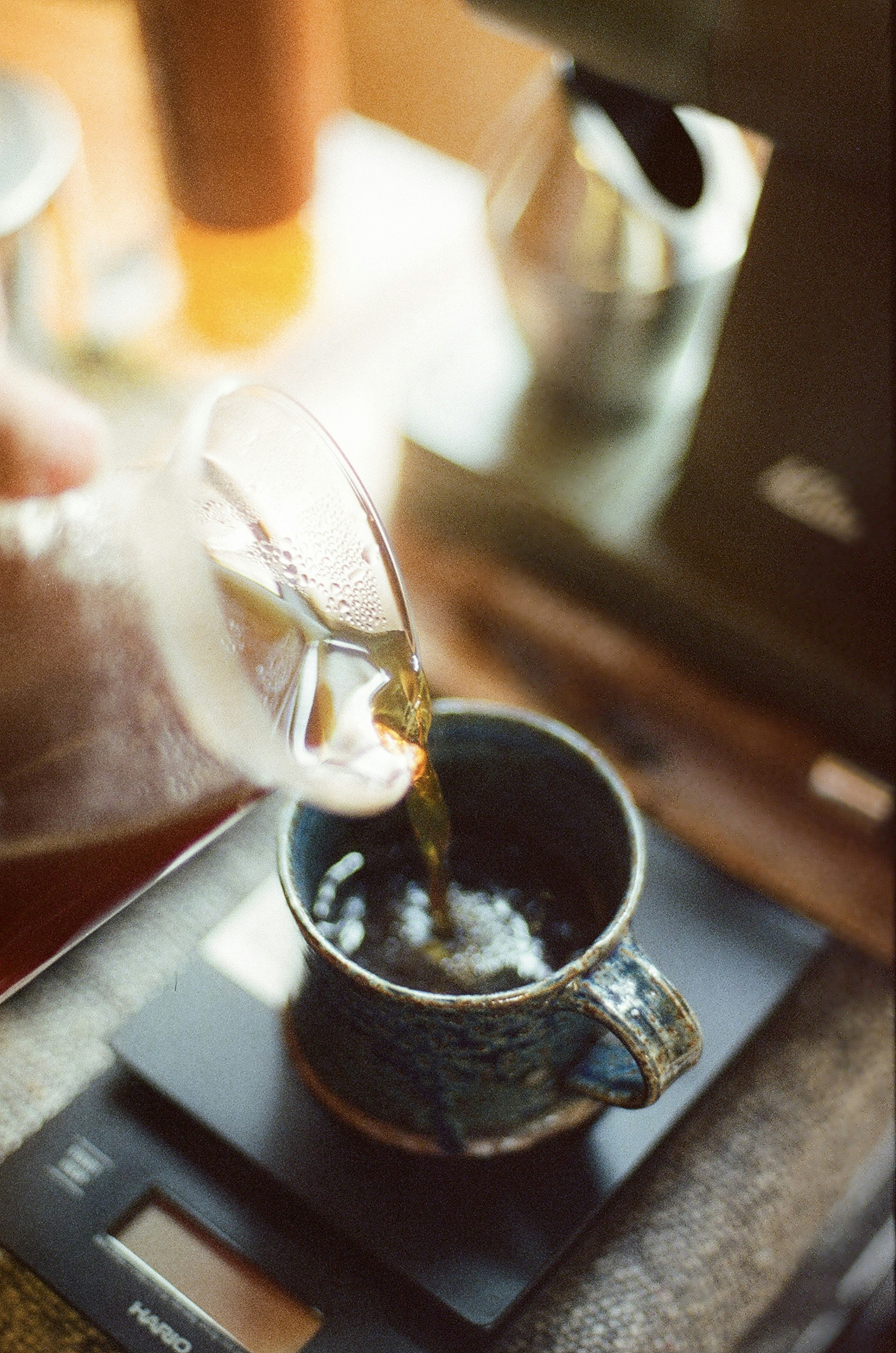 Una escena de vertido de café en una taza colocada sobre una balanza