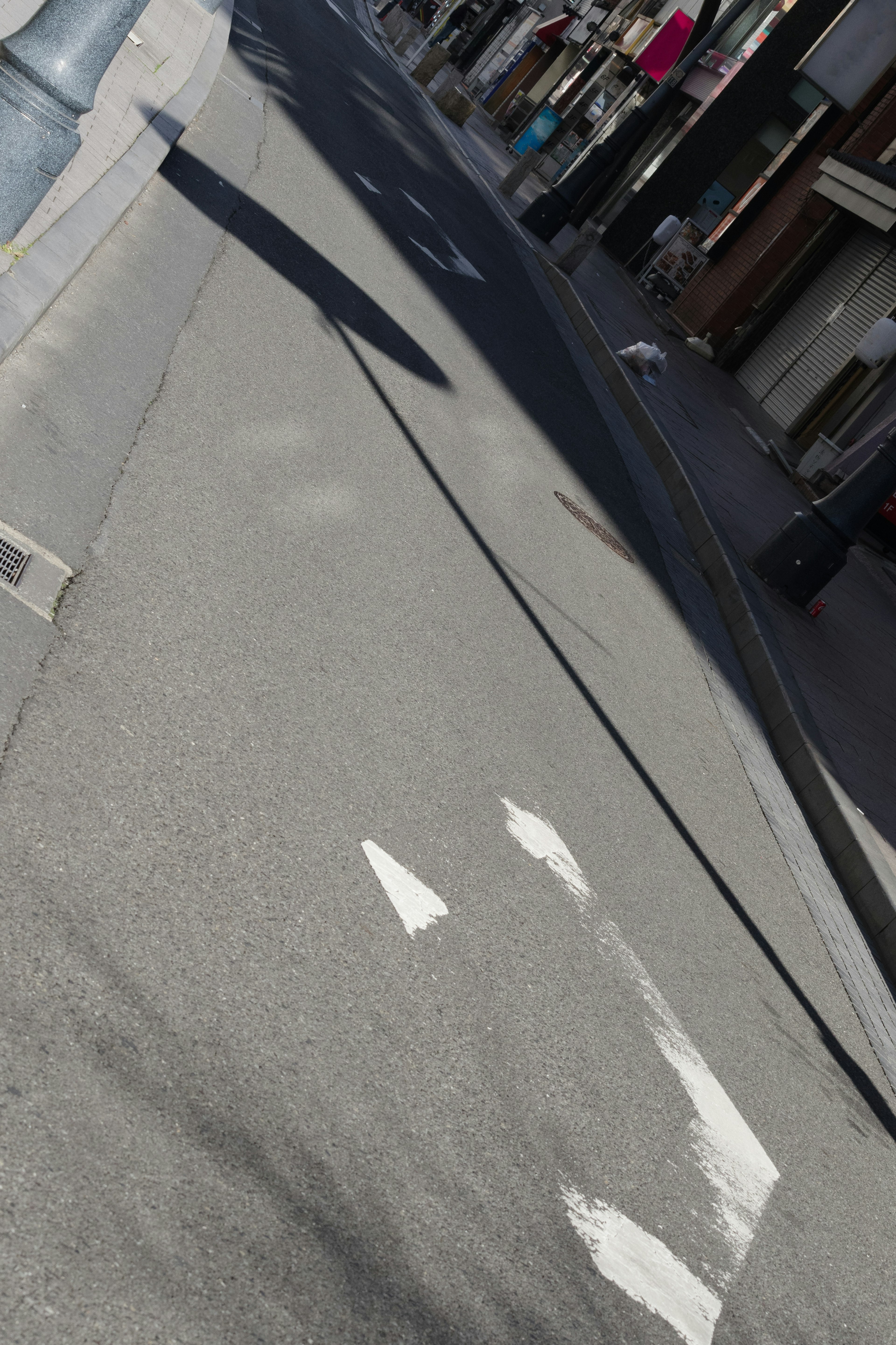 Street scene featuring white directional arrows and shadows