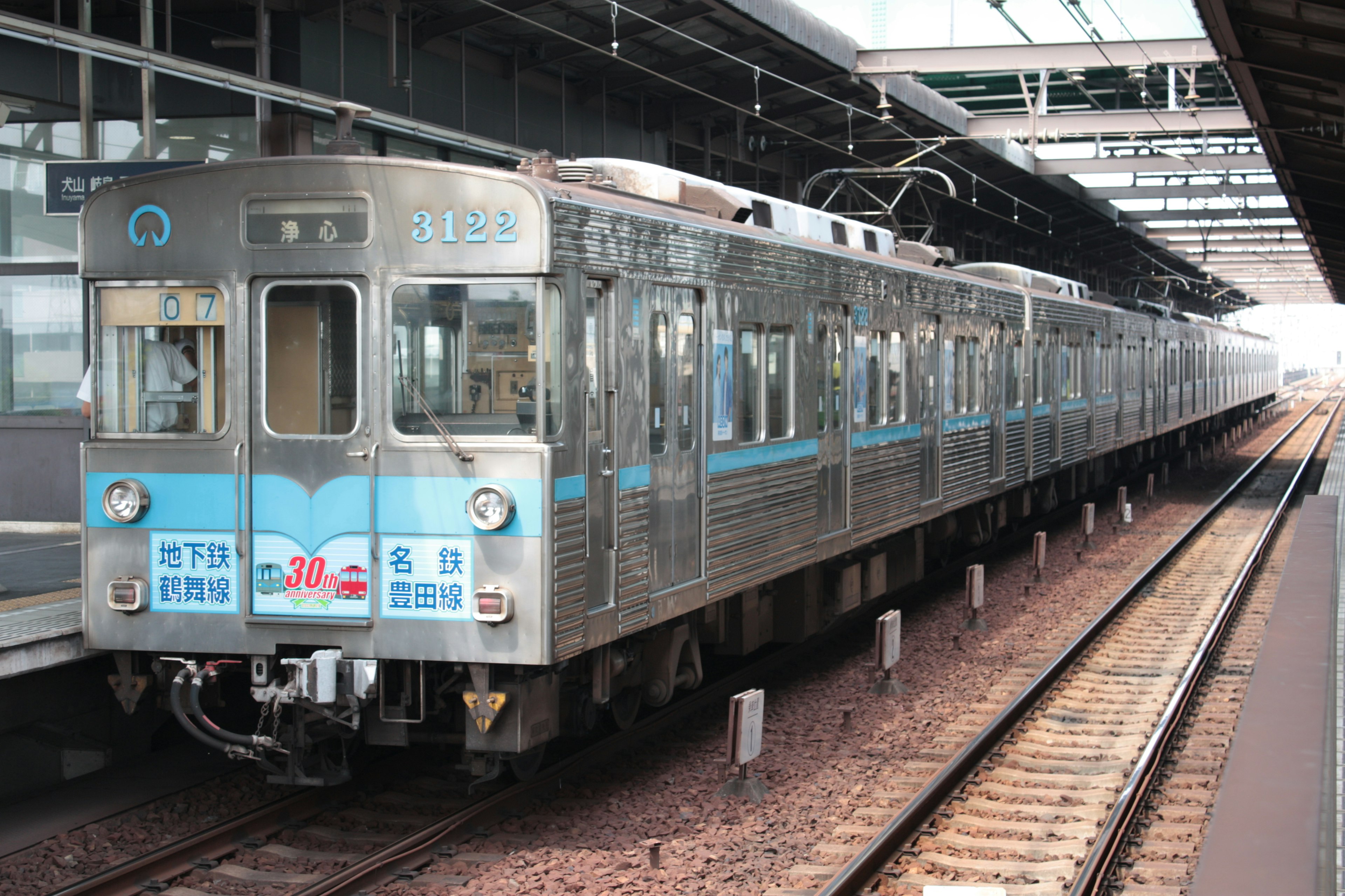 A silver and blue train at a railway station platform