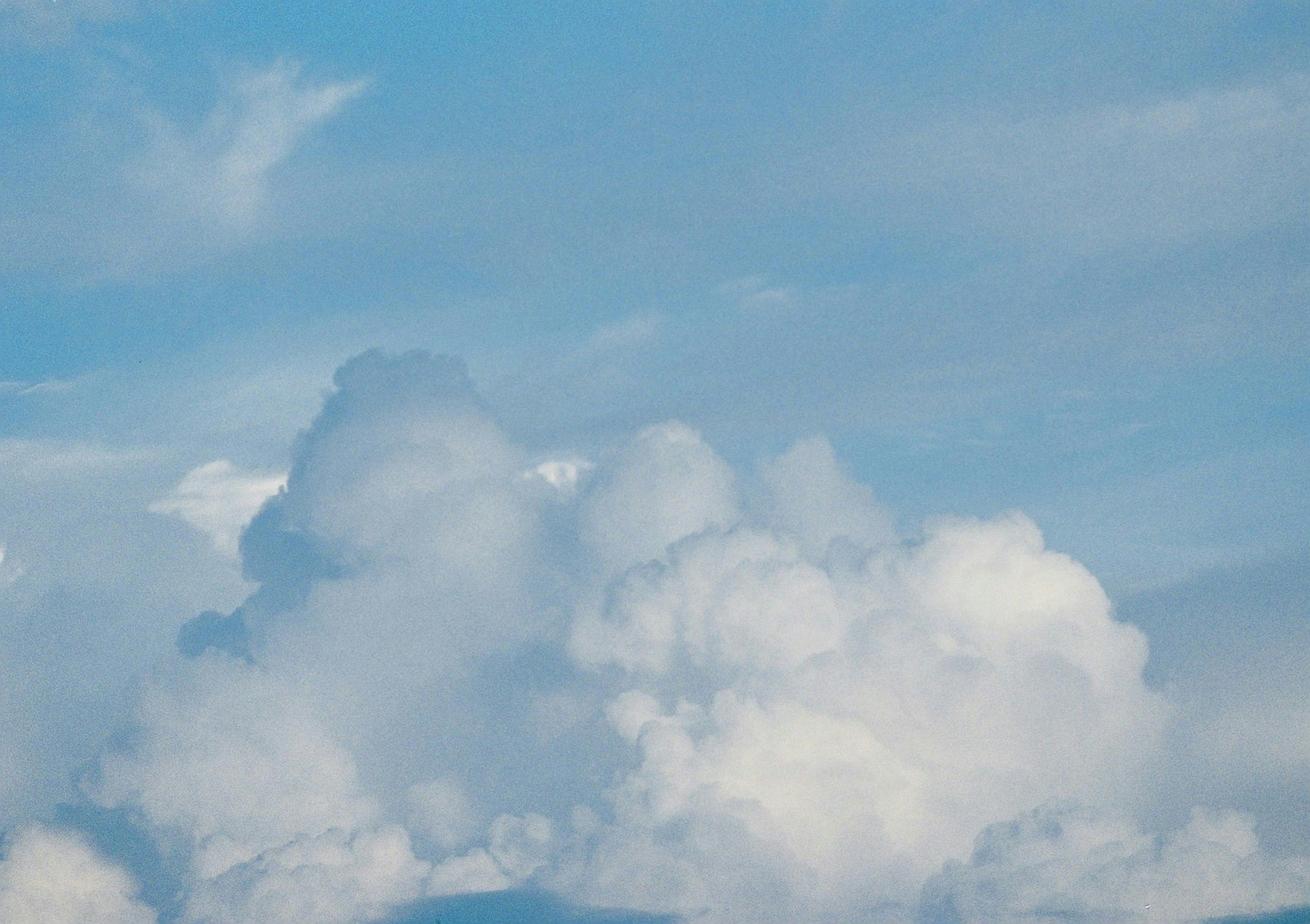 Eine Landschaft mit weißen Wolken, die in einem blauen Himmel schweben