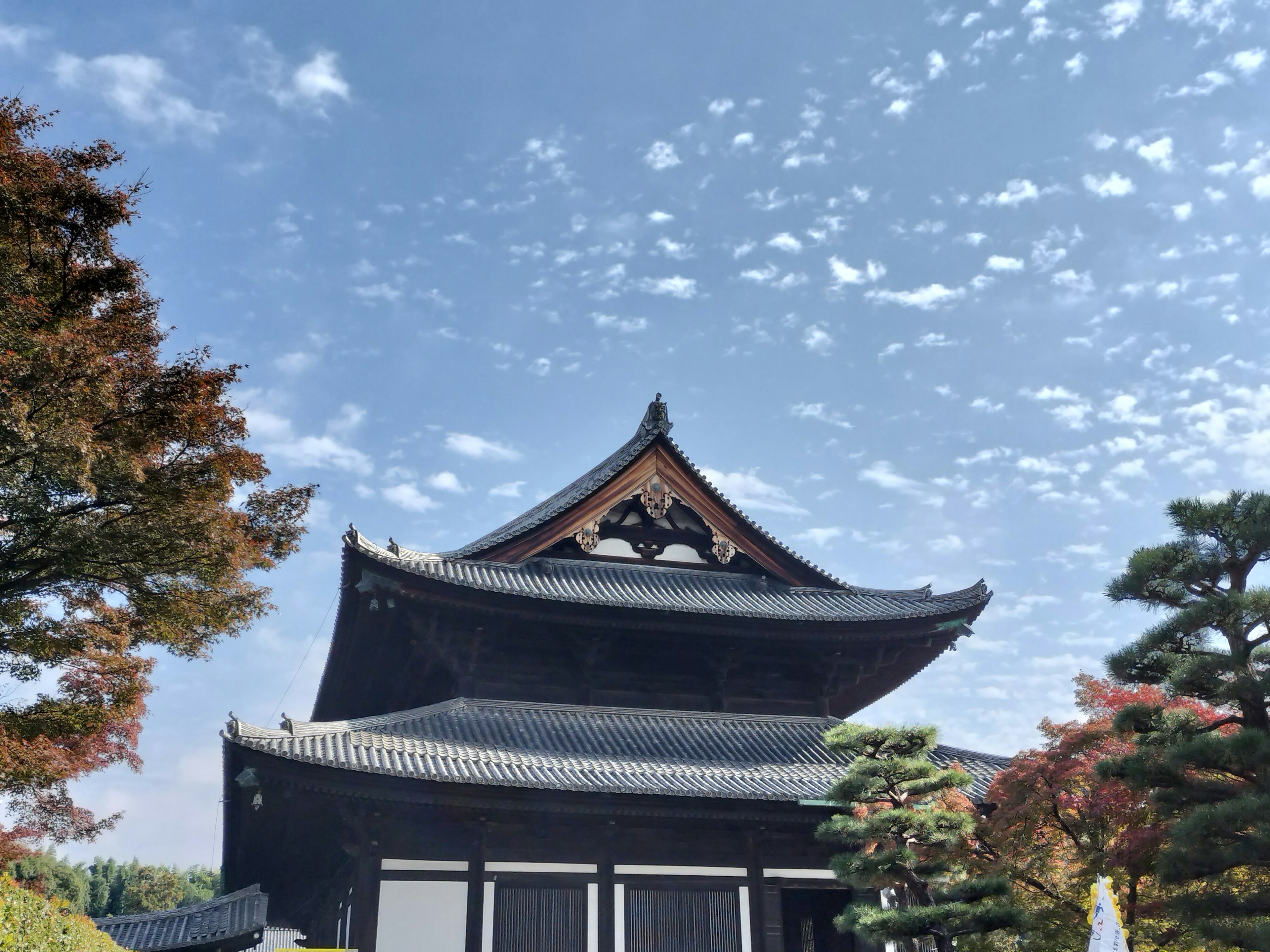 Schöner japanischer Tempel mit schwarzem Dach und blauem Himmel