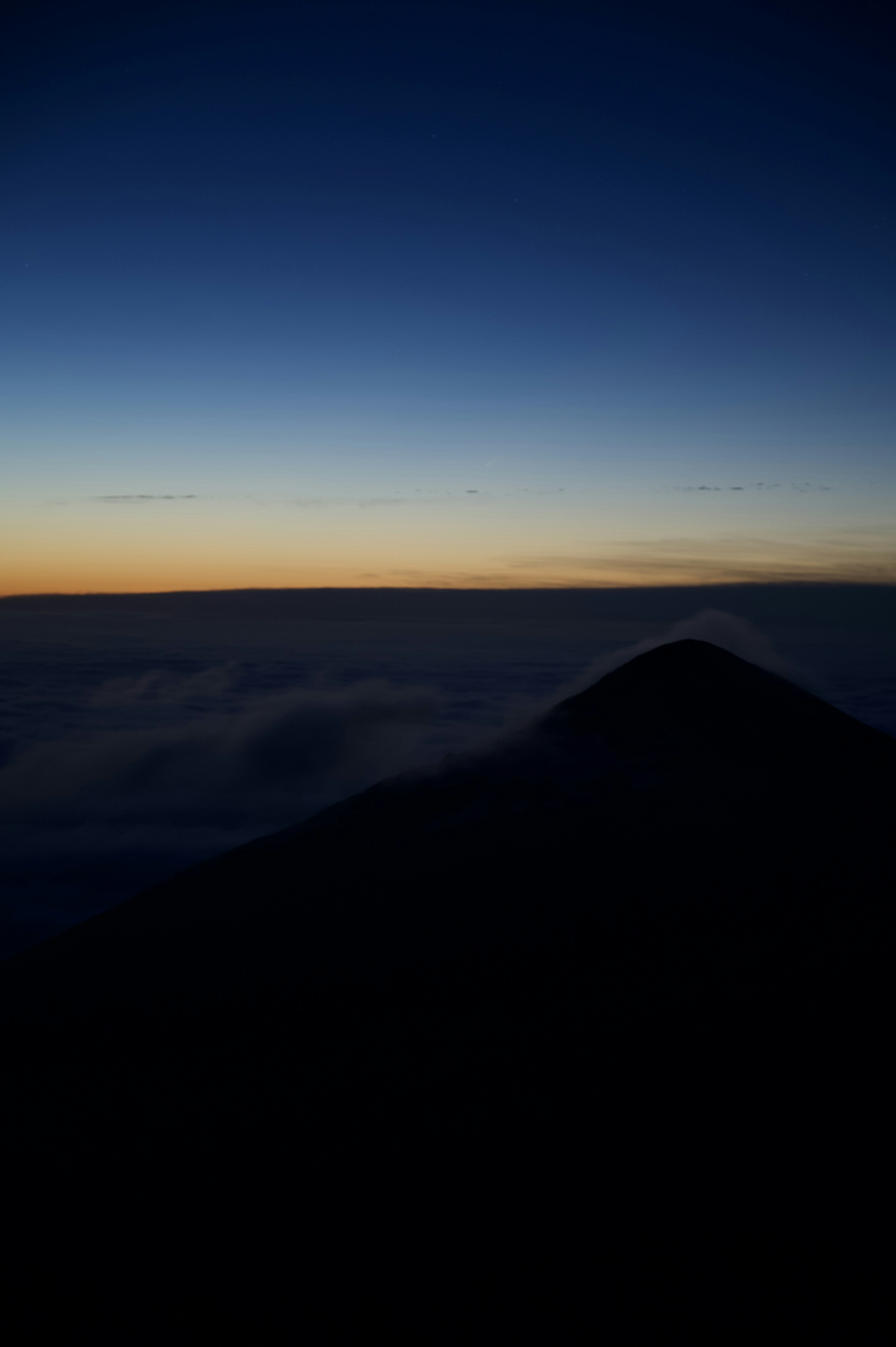 Silhouette of a mountain against a gradient sky