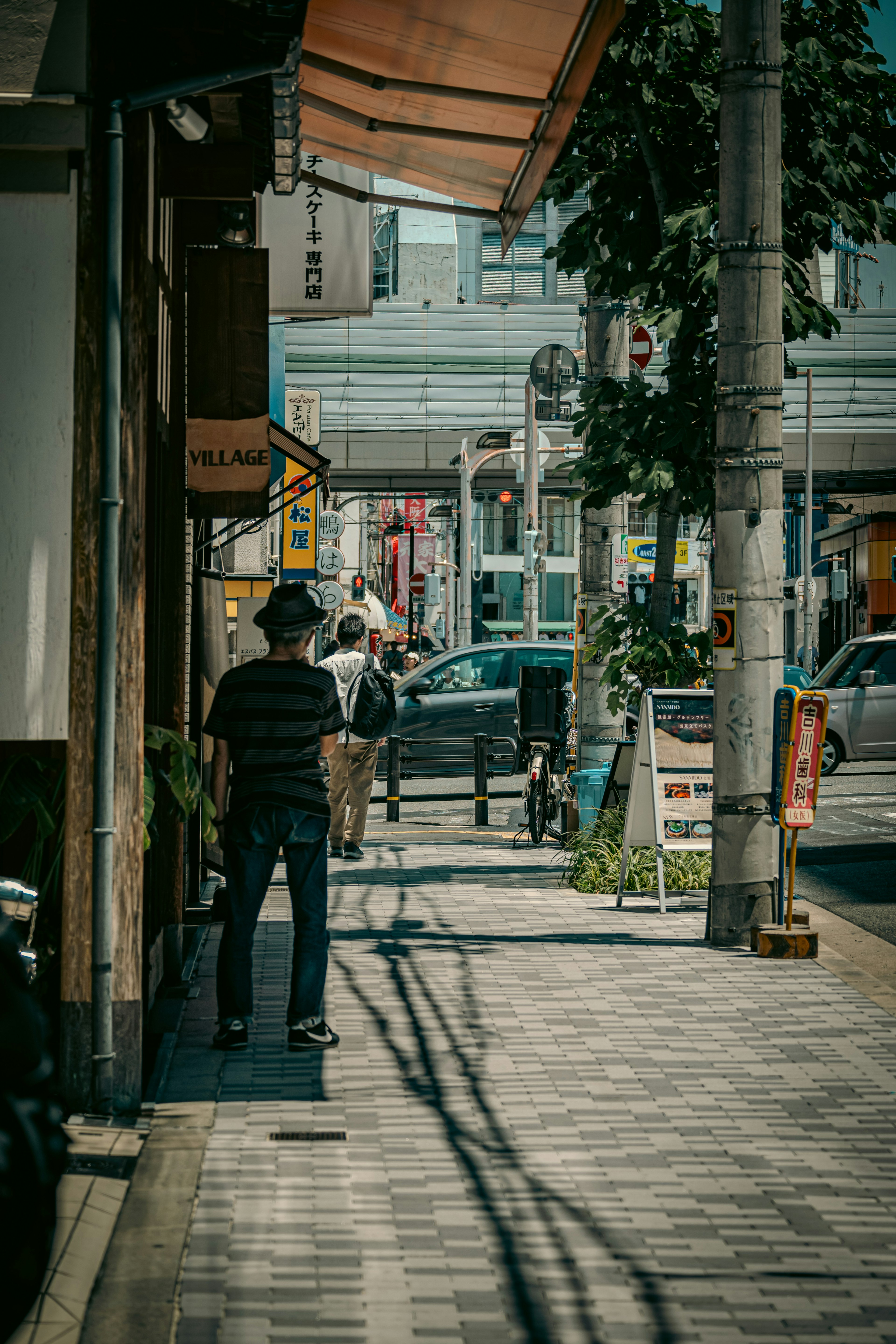 静かな街の通りを歩く男性の後ろ姿