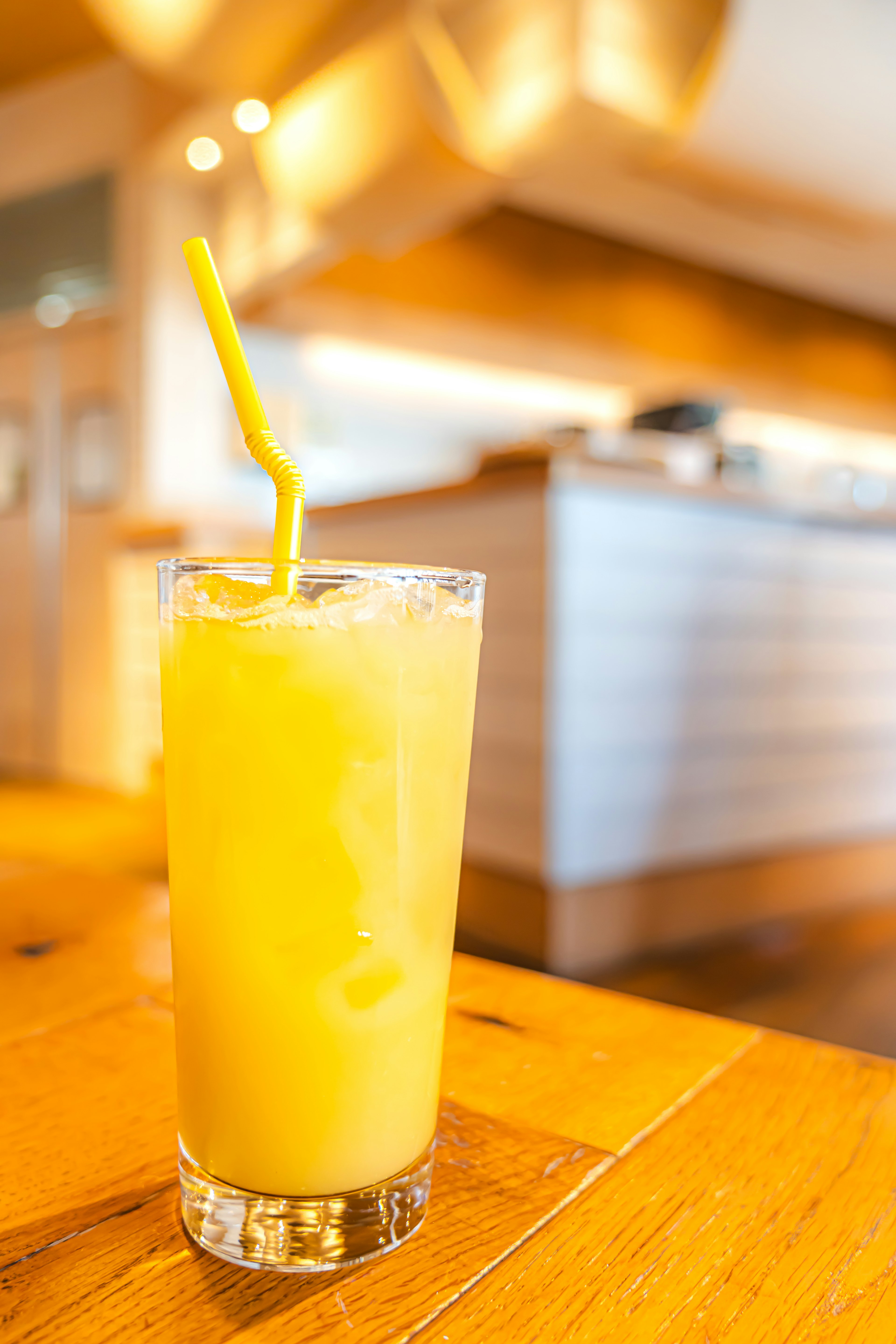 Un verre transparent rempli d'une boisson orange avec une paille