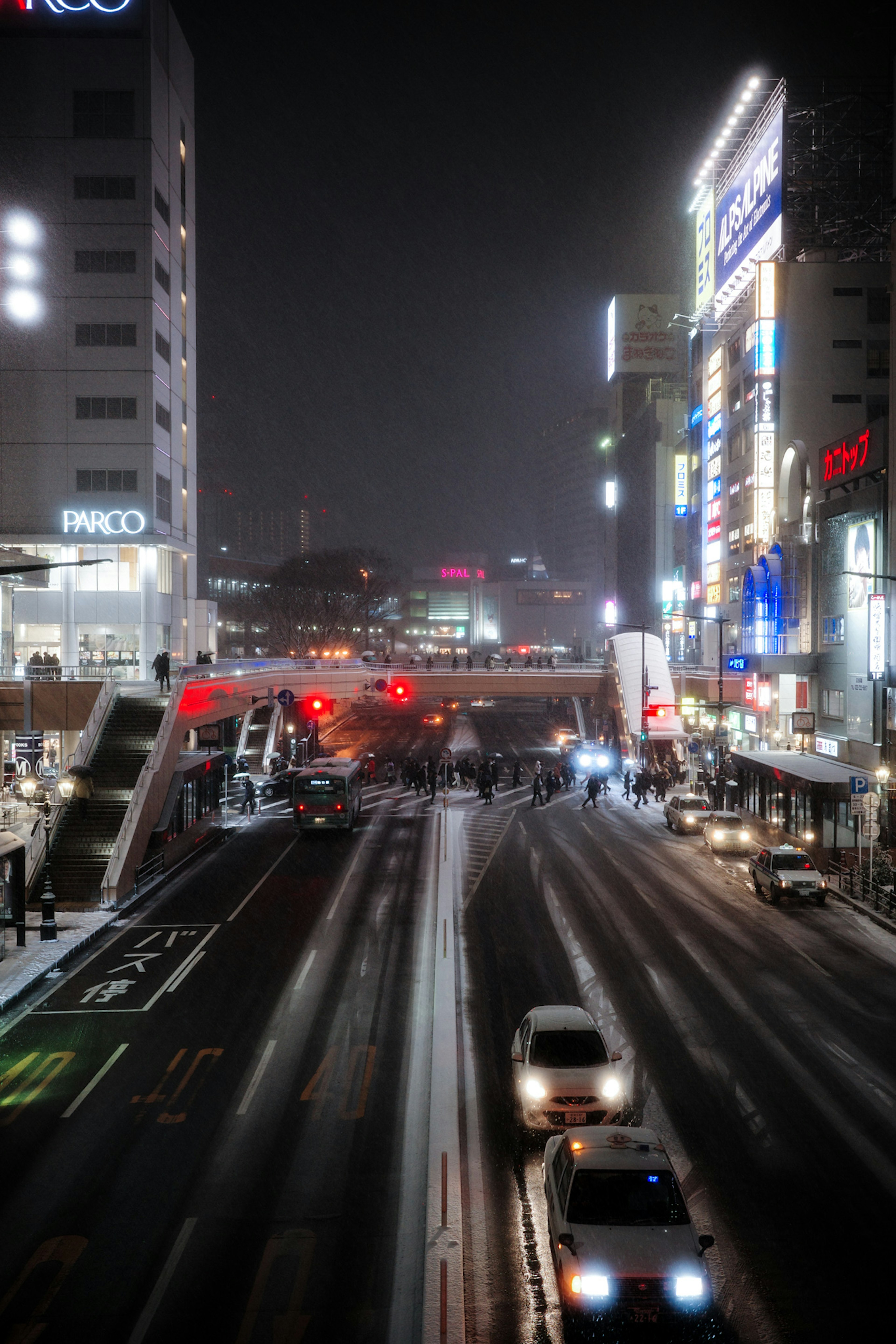 夜の街並みが広がる道路の風景 車が走る交差点と明るい看板