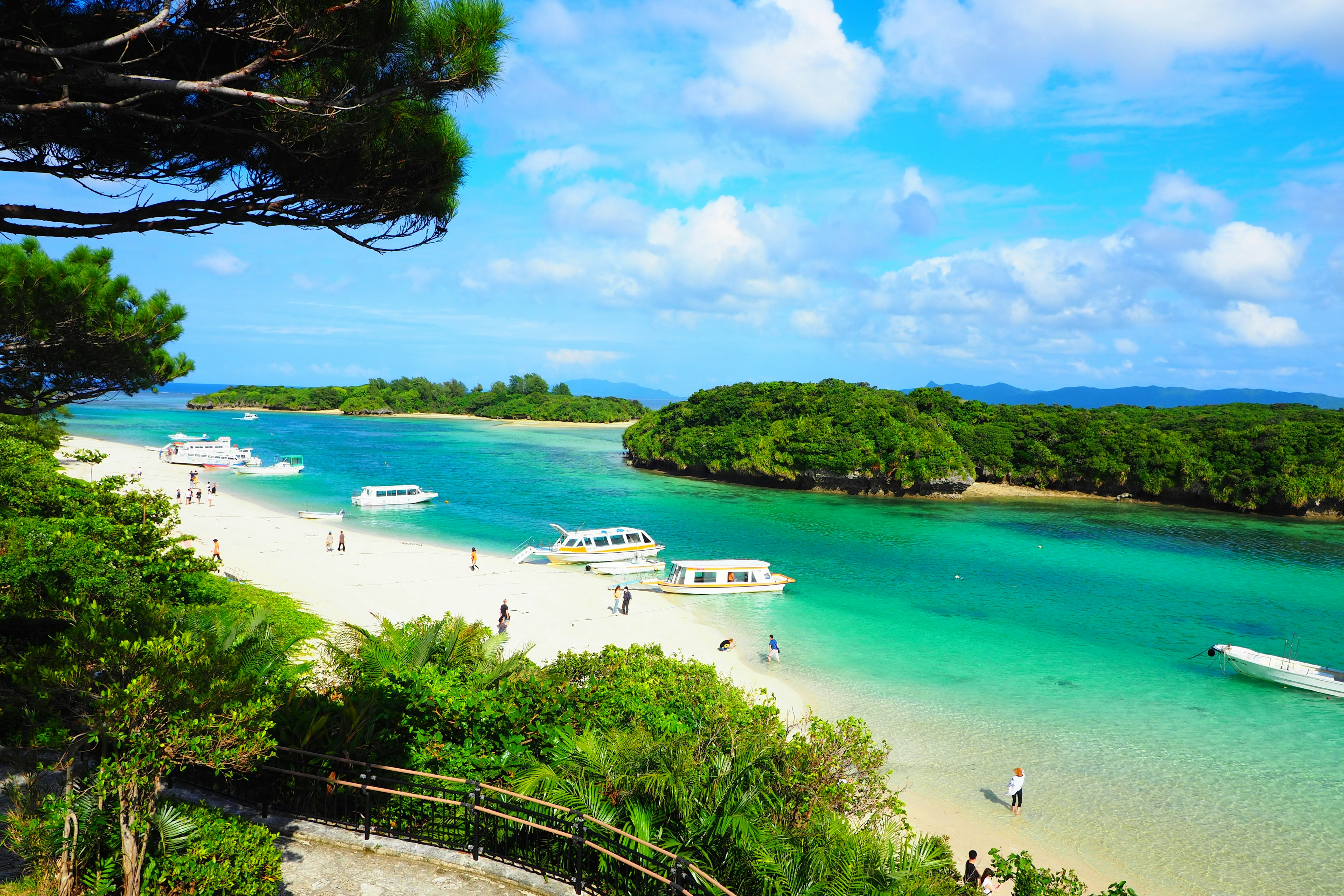 Vista panoramica di acque turchesi e spiaggia di sabbia bianca con barche