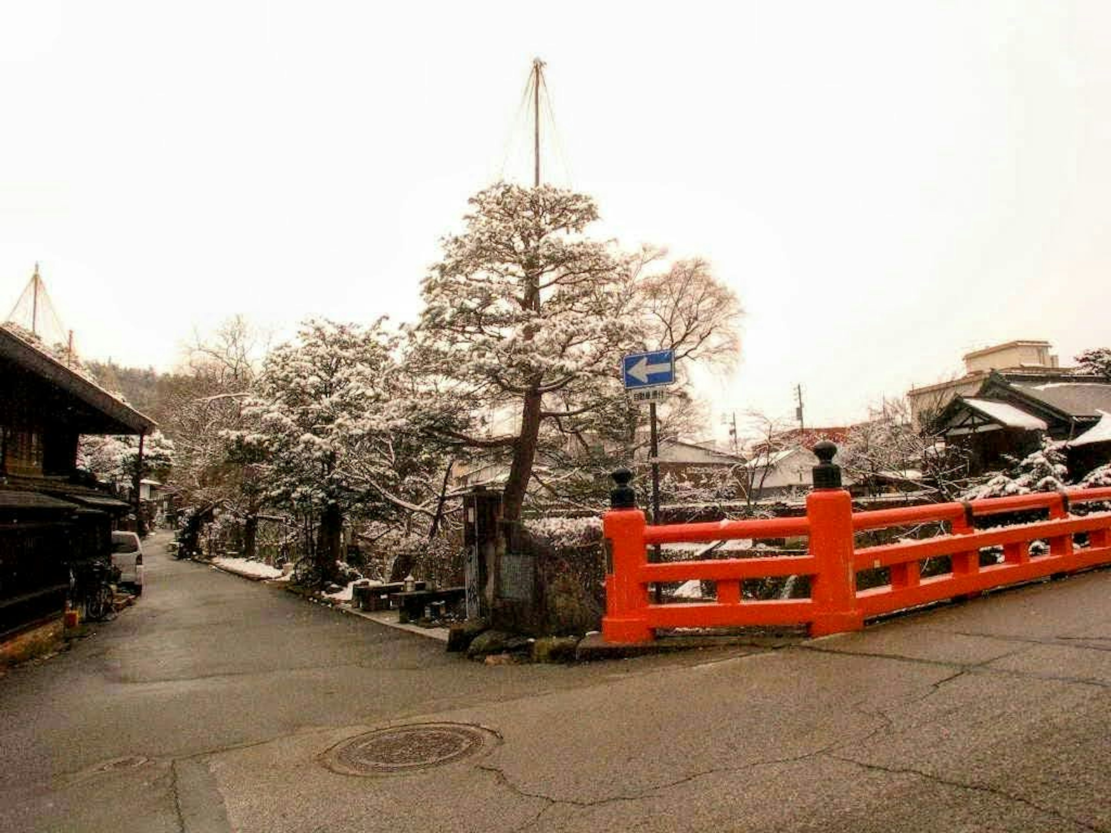 Puente rojo cubierto de nieve con paisaje circundante