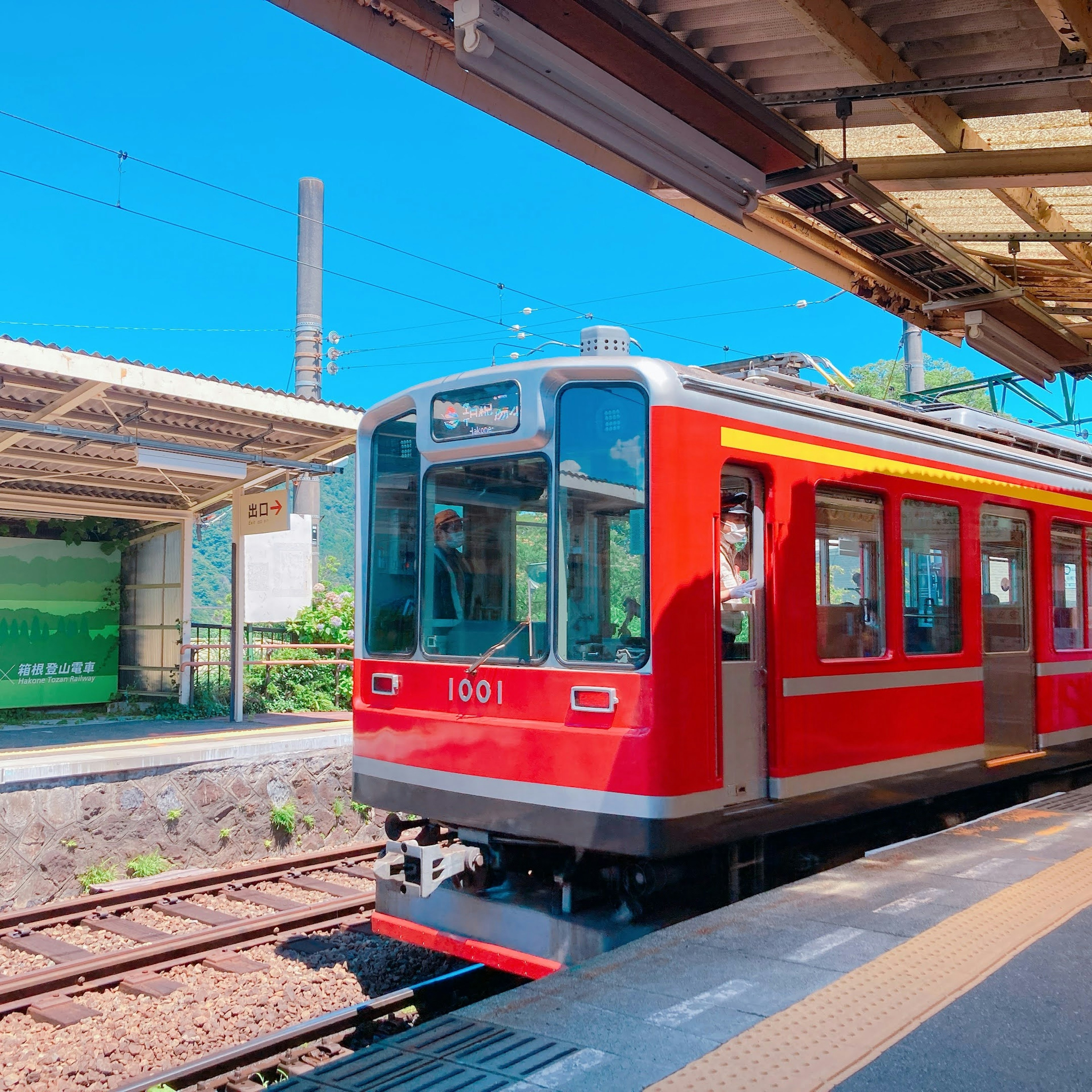 Treno rosso in stazione con cielo blu chiaro