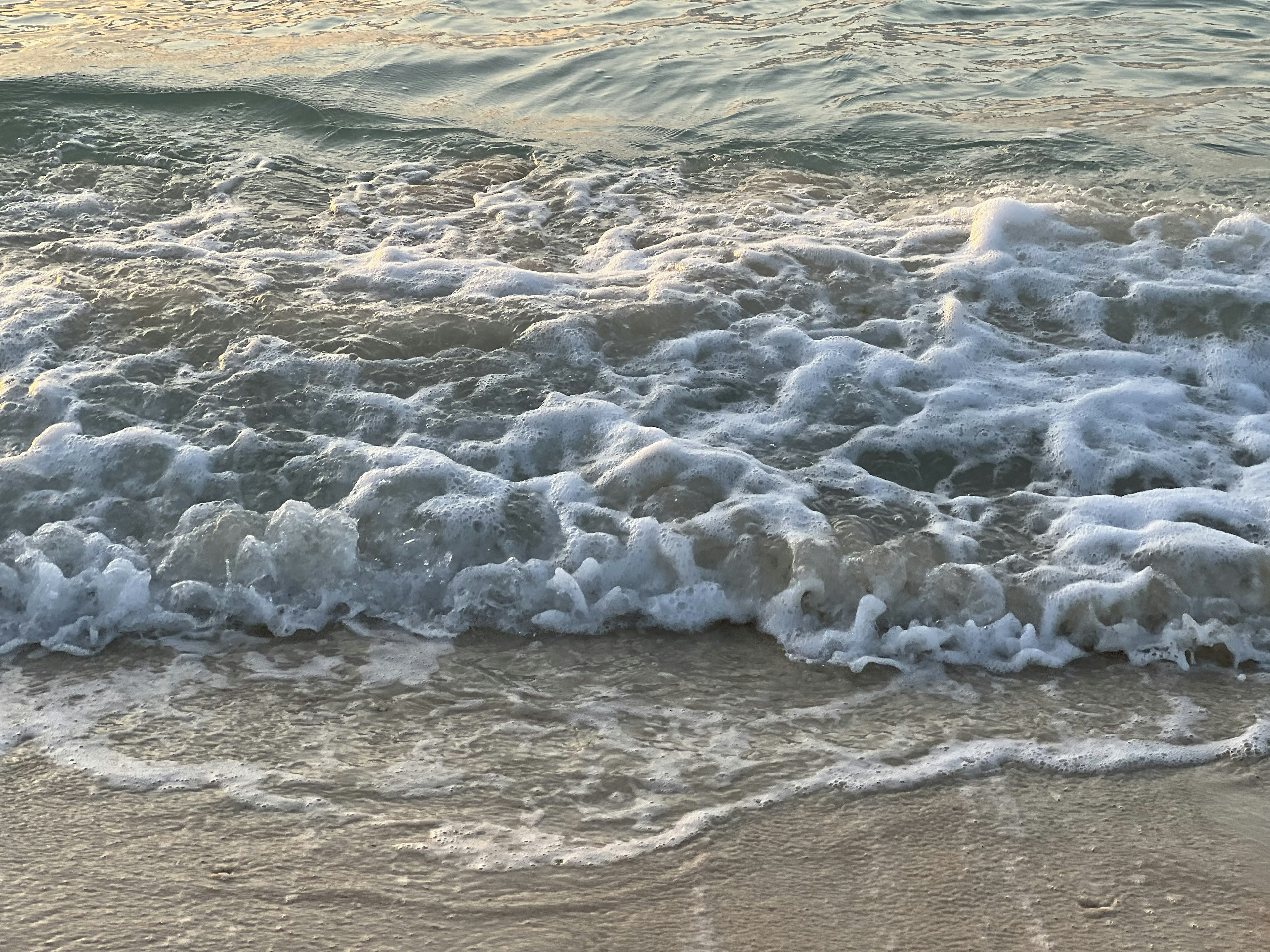 Wellen brechen an einem Sandstrand