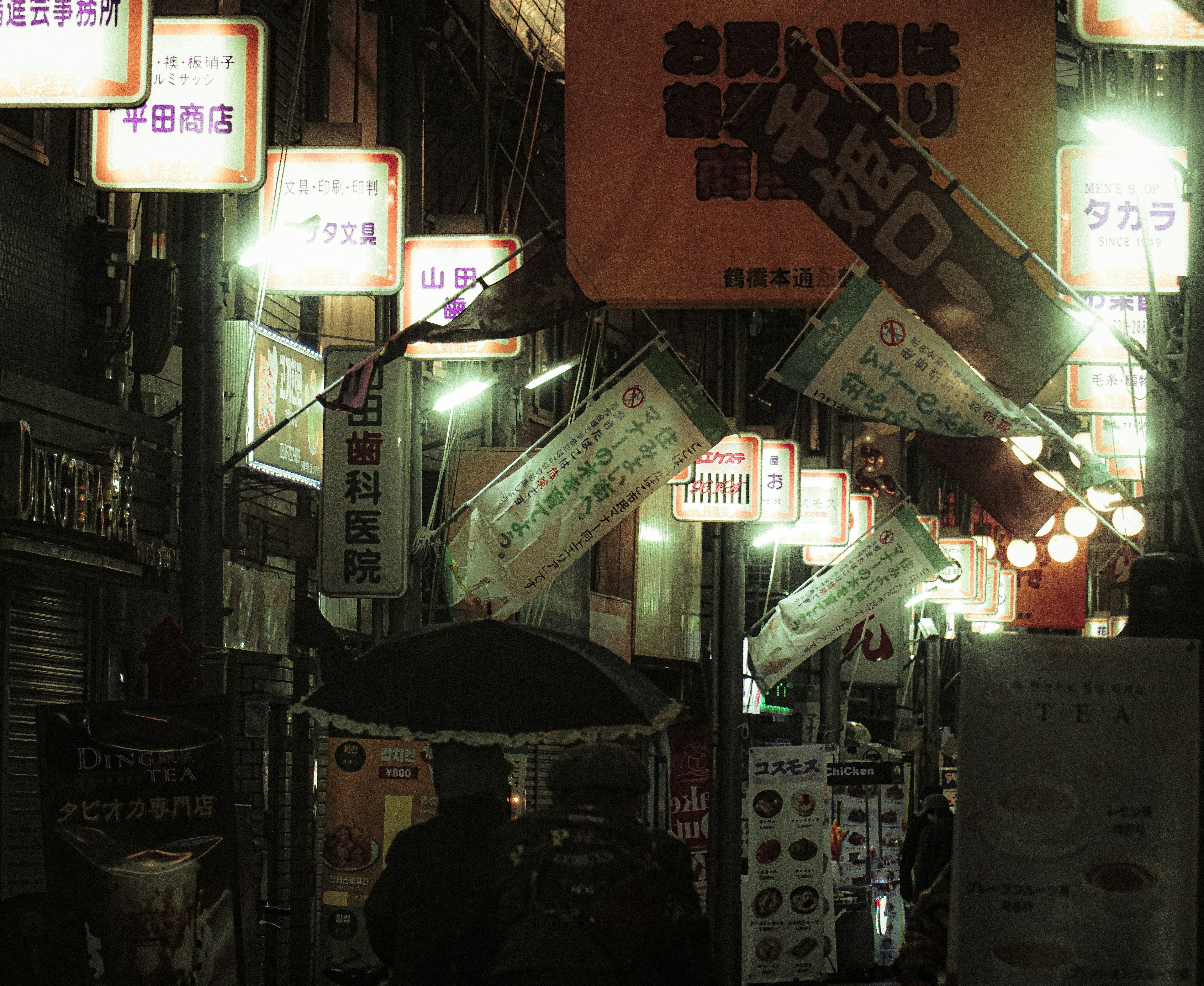 Night scene of a shopping street illuminated by lanterns and signs