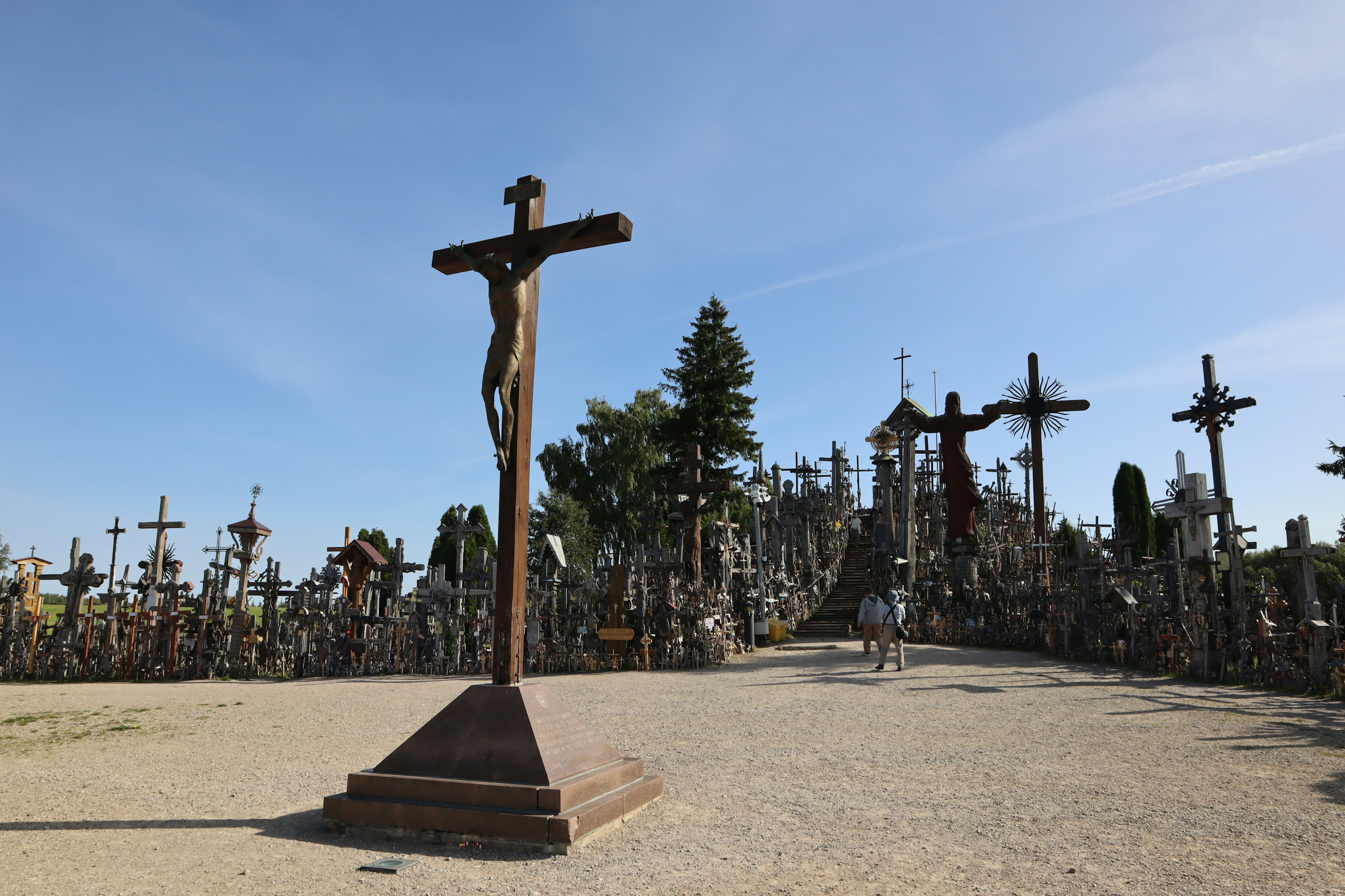 Paisaje de una colina con una cruz rodeada de numerosas cruces en un sitio sagrado