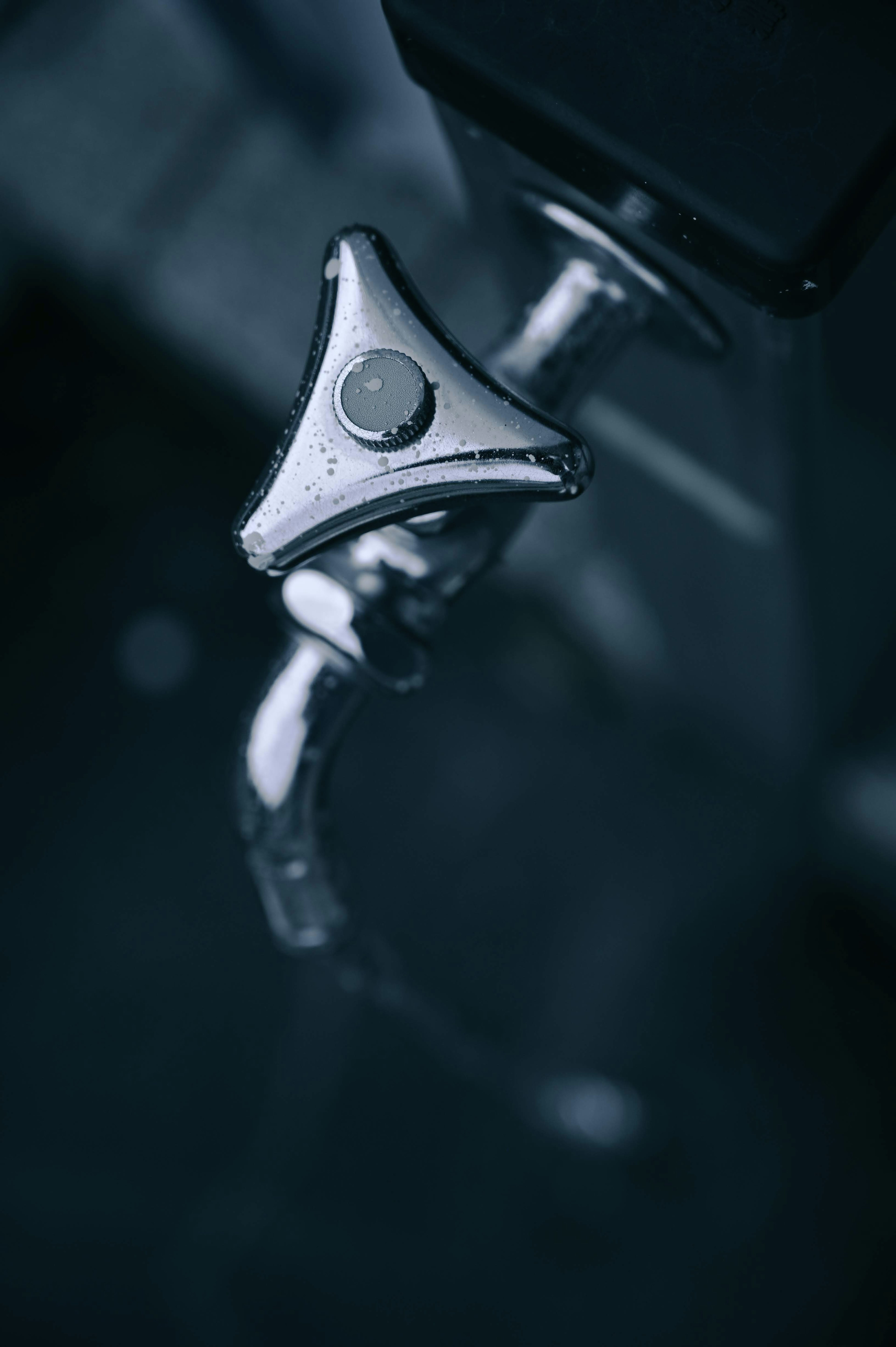 Close-up of a faucet featuring a sleek metal handle with a minimalist design