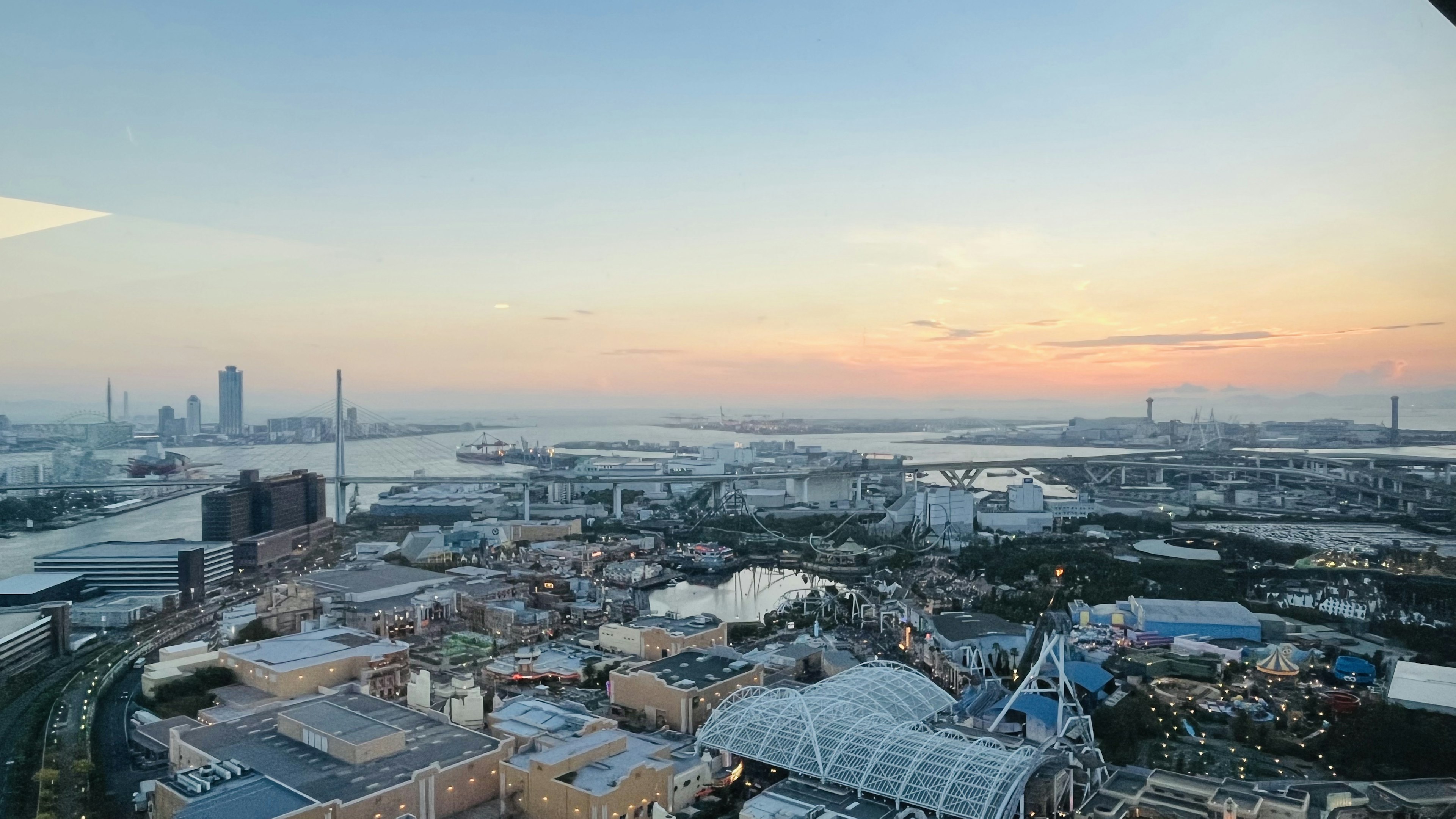 高層ビルからの都市のパノラマビュー夕焼けの空と川が広がる